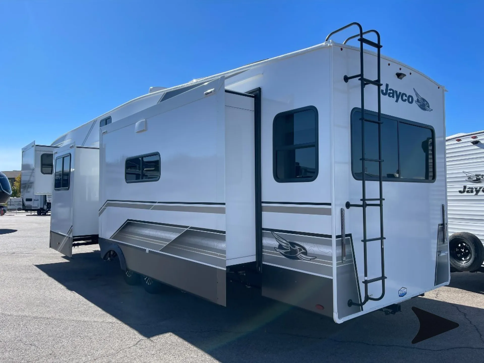 2027 Jayco Eagle 355MBQS — Outdoor photograph clearly shows the RV's exterior shell, slide-outs, windows, ladder, and branding