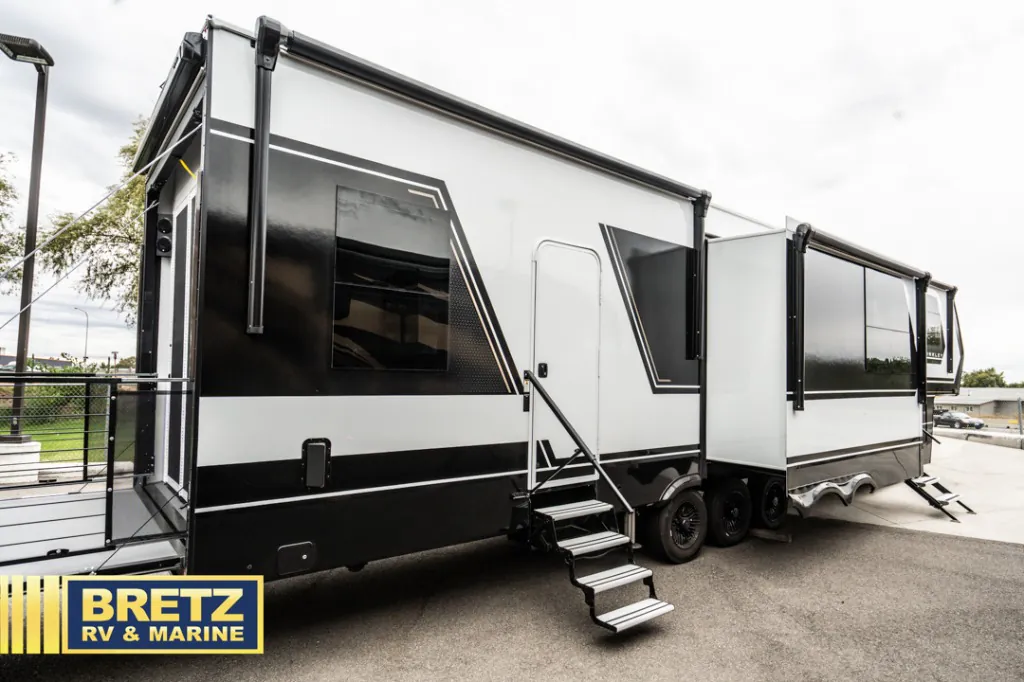 2026 Brinkley Model G 3950 — The RV's exterior side, slide-outs, windows, wheels, and entry steps