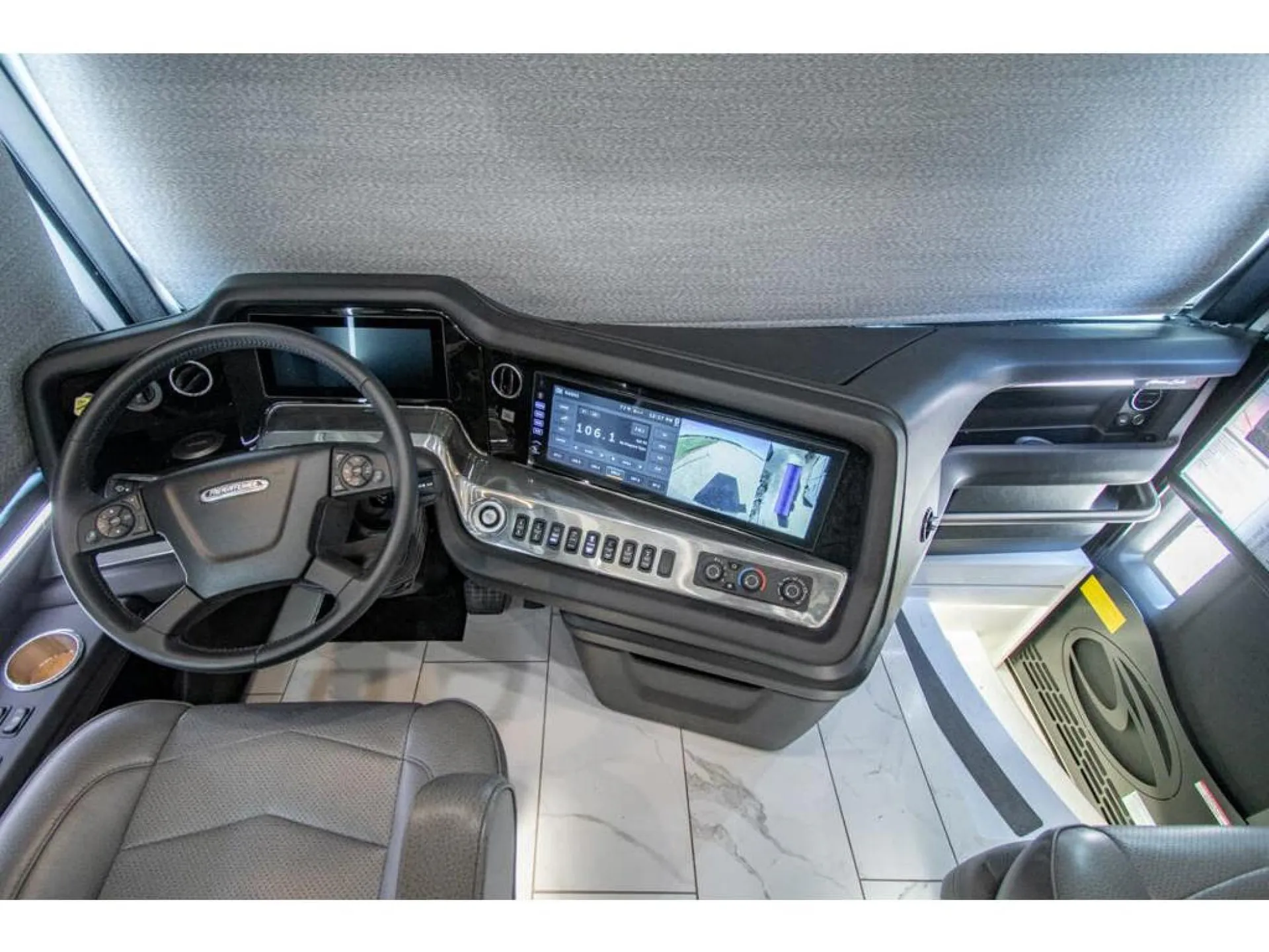 2026 American Coach American Dream 45A — Class A cockpit with steering wheel, instrument cluster, dashboard touchscreen, climate controls, and passenger-side console