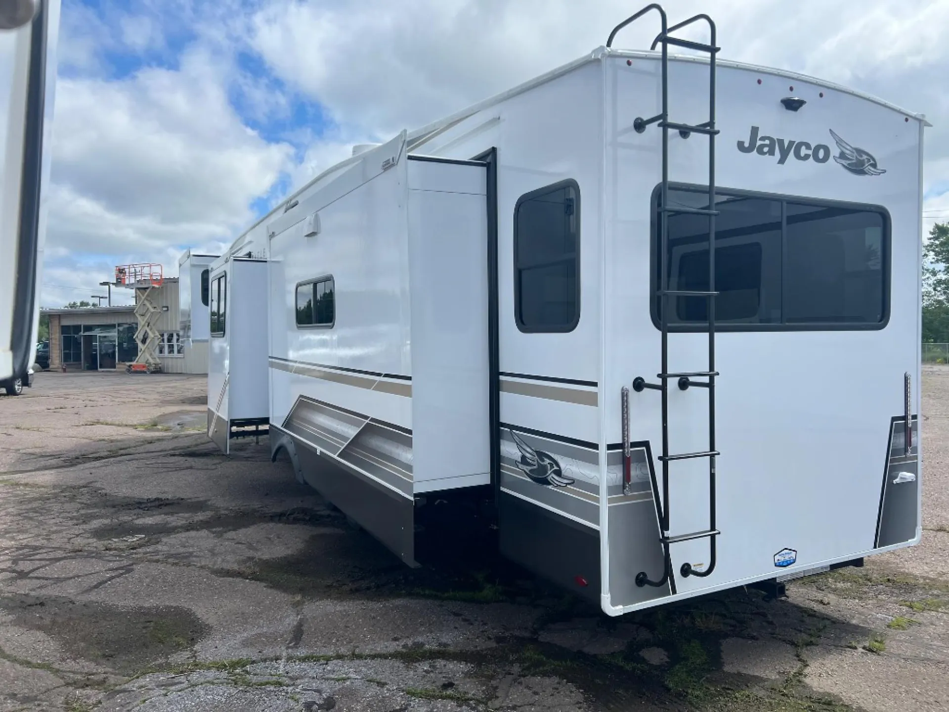 2027 Jayco Eagle 355MBQS — The RV's exterior rear and side, including ladder and slide-outs