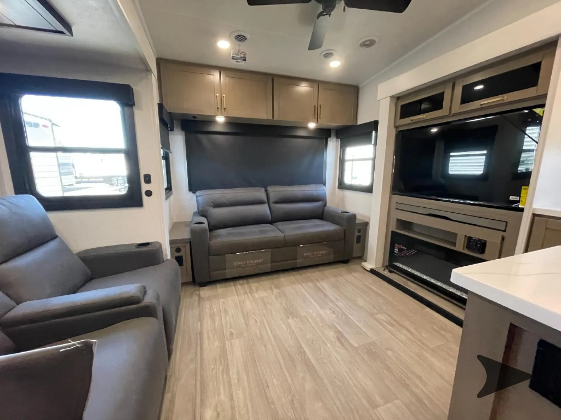 2027 Jayco Eagle 355MBQS — Fifth wheel living area with opposing recliners, a sofa, entertainment center, and surrounding windows