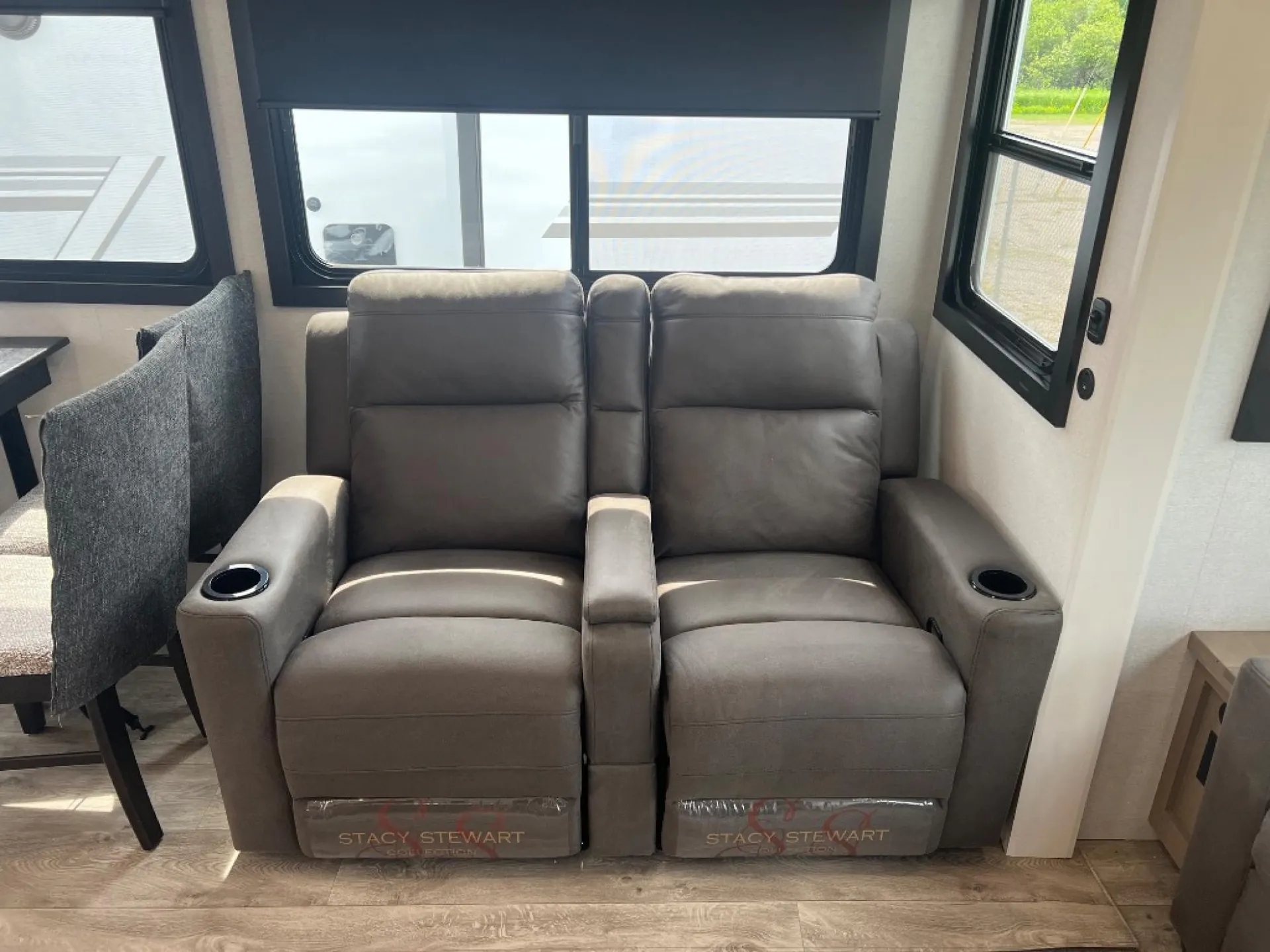 2027 Jayco Eagle 355MBQS — Pair of padded theater recliners with cup holders positioned beside the fifth wheel dining area