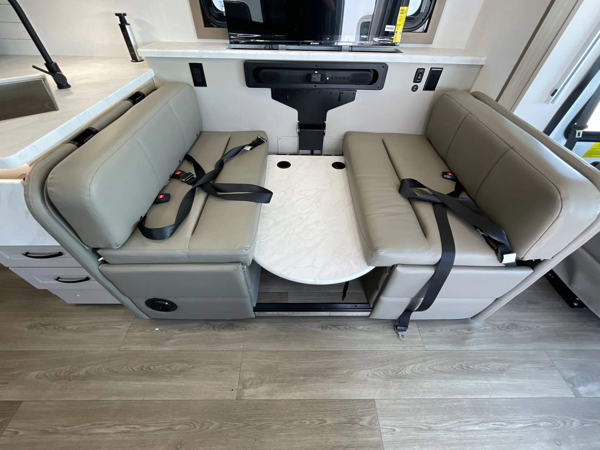 2027 Jayco Alante 29F — Booth dinette with seat belts and table beside a kitchen counter, sink, faucet, and upper cabinetry