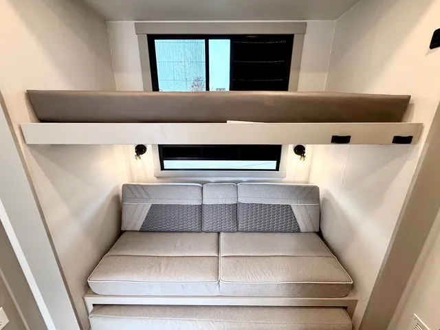 2026 Brinkley Model Z 3610 — Elevated loft mattress and sofa beneath two windows in a fifth wheel interior