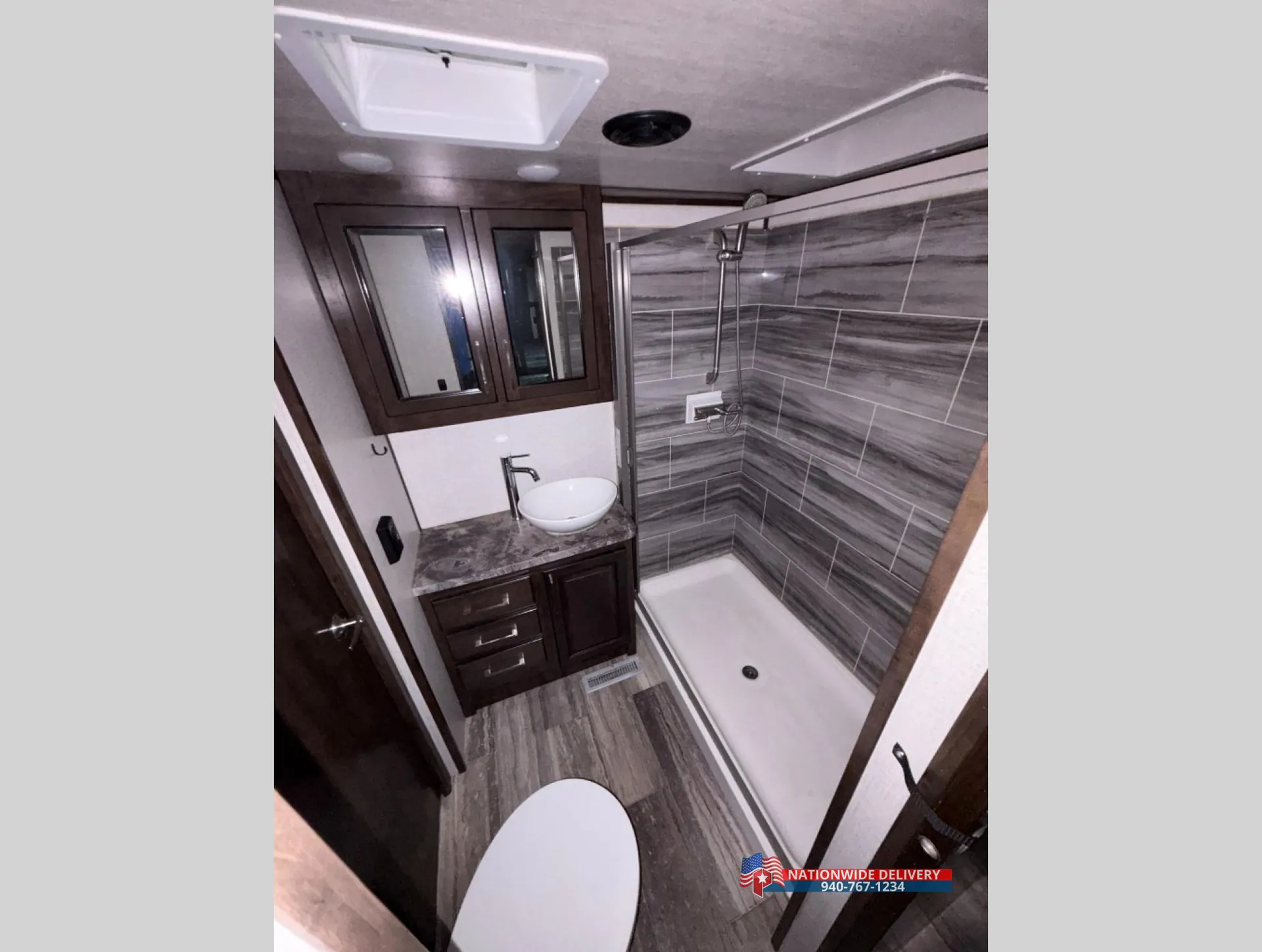 2022 Dutchmen Voltage 4225 — Fifth wheel bathroom with corner shower, toilet, vessel sink, vanity, and mirrored storage cabinet