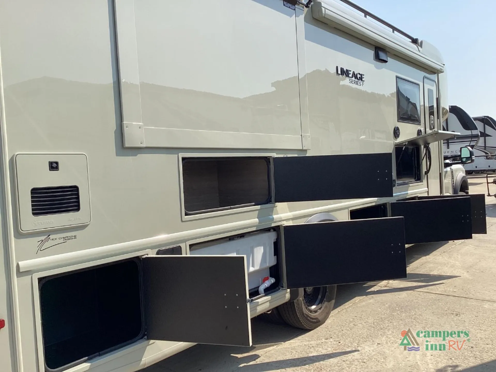 2027 Grand Design Lineage Series F 31ZW — Wide exterior photograph shows the RV side with multiple open cargo and storage compartments
