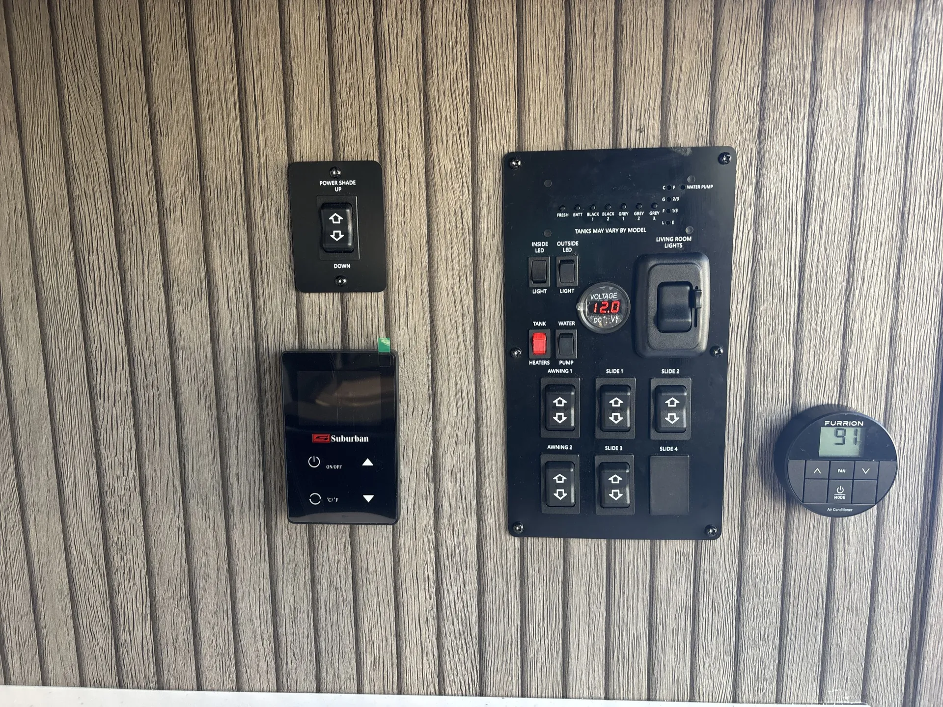 2026 Forest River Arctic Wolf 38LEAH.G — RV control panel with water and tank indicators, slide controls, lighting switches, furnace thermostat, and power shade switch
