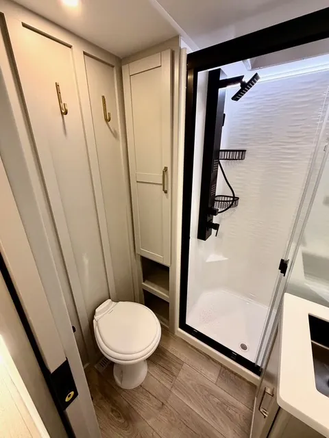 2026 Brinkley Model Z 3610 — Bathroom with toilet, glass shower, tall cabinet, and vanity edge visible