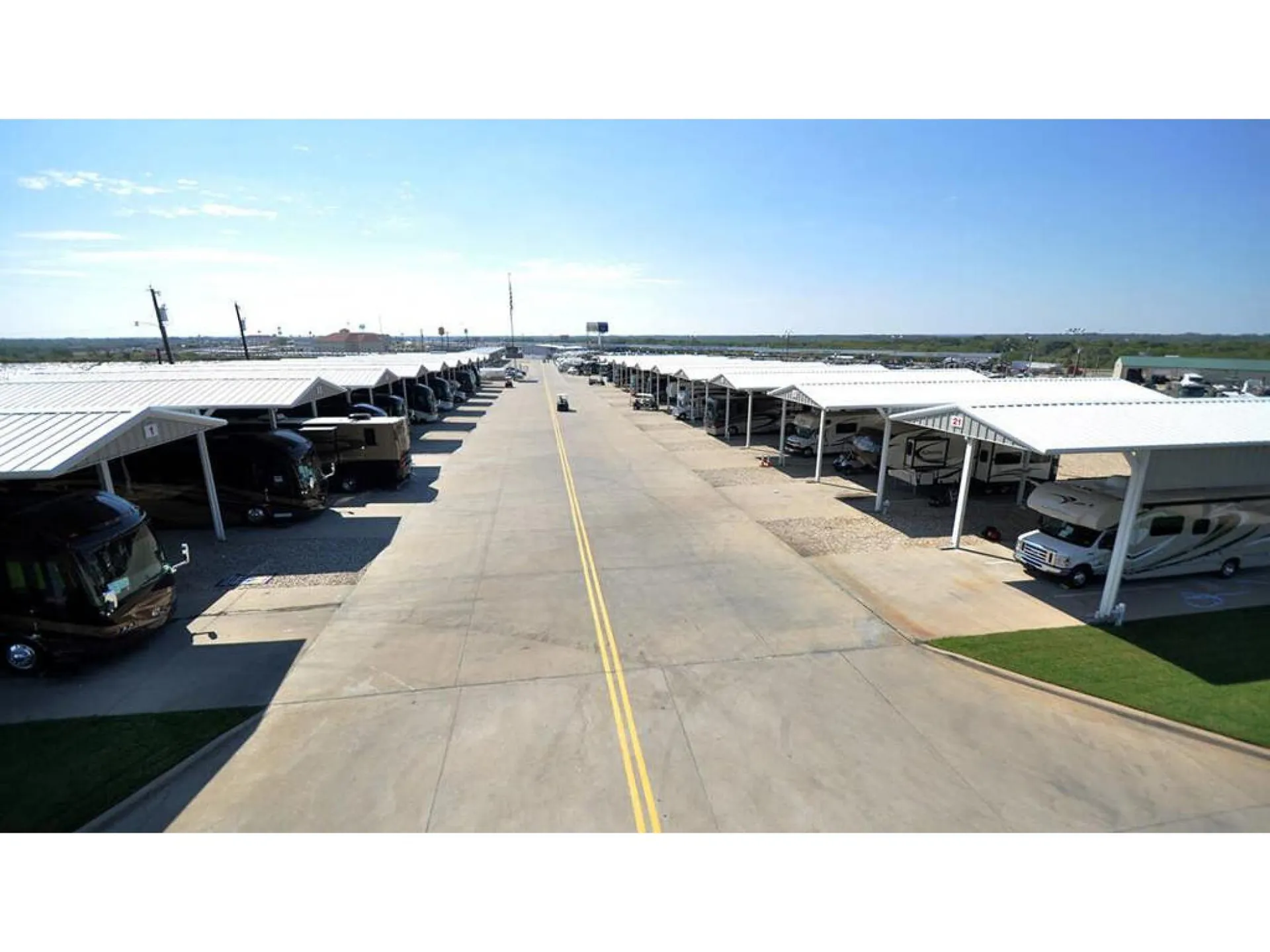 2026 Fleetwood Discovery LXE 40G — Wide photograph of a covered RV storage facility and many parked RVs; no specific unit or exterior feature is the primary subject