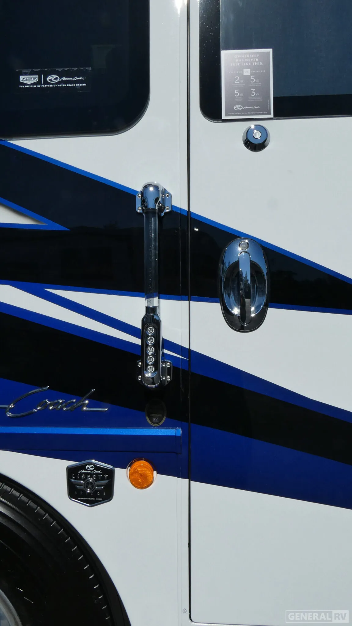 2026 American Coach American Dream 45A — Close photograph of the RV's exterior body, entry hardware, graphics, and wheel area