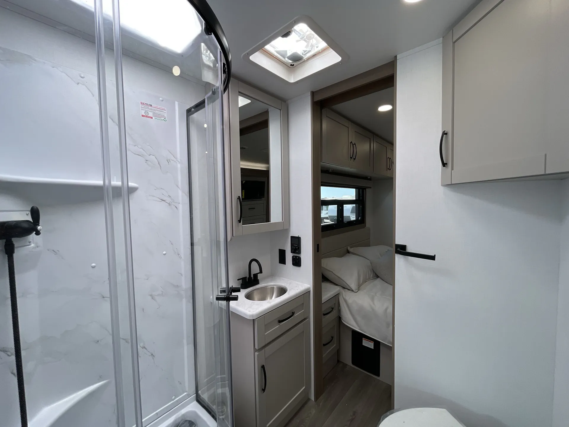 2027 Jayco Alante 29F — Bathroom with glass shower, vanity sink and mirror opening directly toward the main bedroom