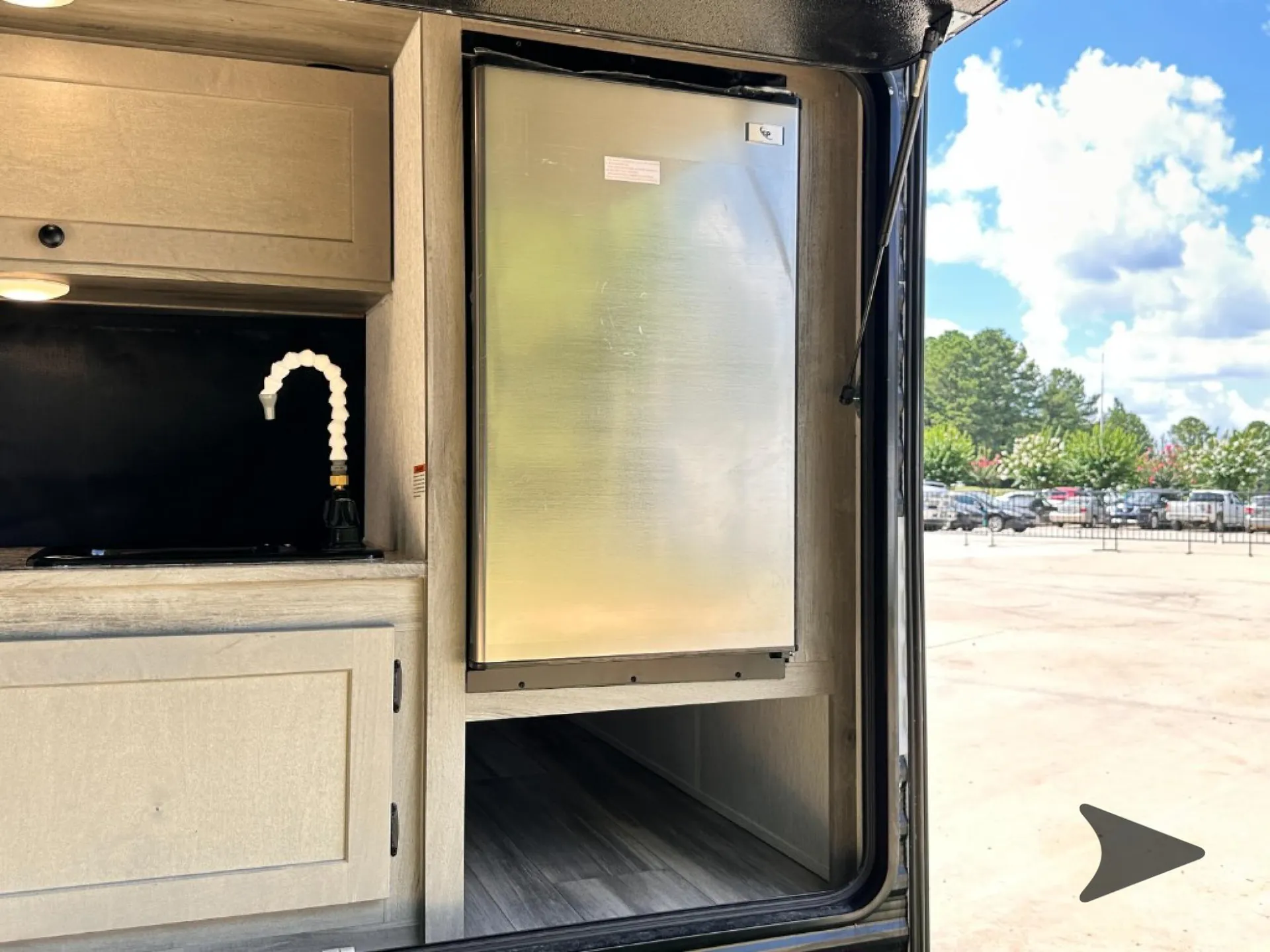 2026 Wayfinder Go Lite Solo — Close photograph of the exterior-installed galley, clearly showing the sink area and refrigerator