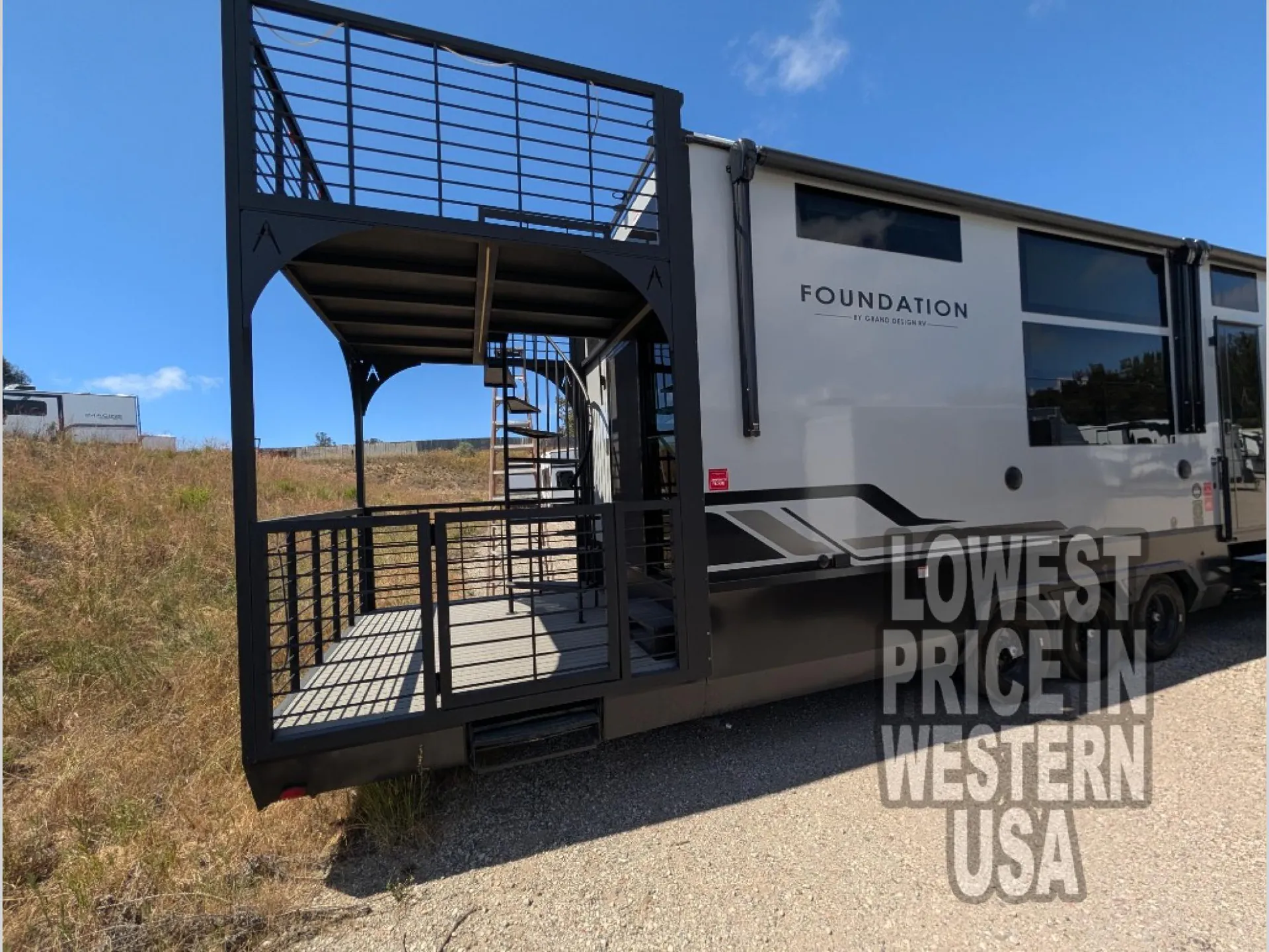 2026 Grand Design Foundation 42GD — Wide exterior photograph of the RV side and elevated rear deck with railings and stairs