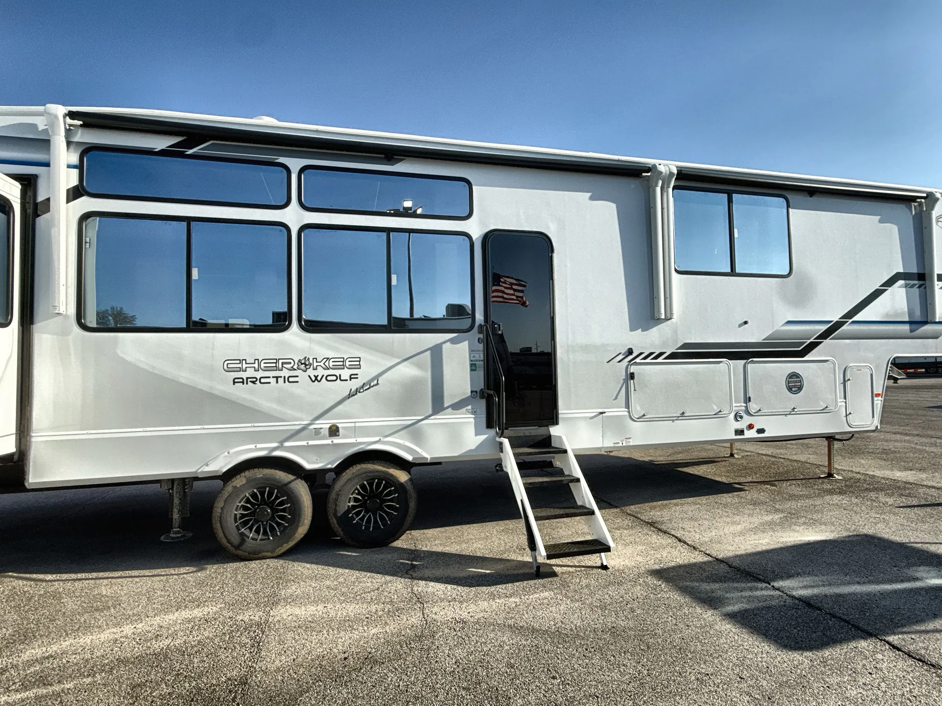 2026 Forest River Arctic Wolf 38LEAH.G — Wide photograph clearly shows the physical fifth-wheel RV exterior, slide-outs, entry steps, awning, and storage doors