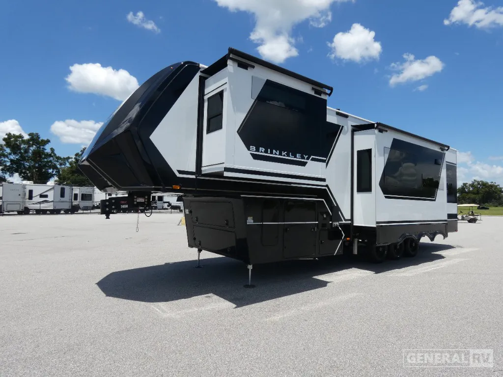 2026 Brinkley Model G 3250 — The outside front and side of the fifth-wheel RV, including hitch, storage compartments, and slide-outs