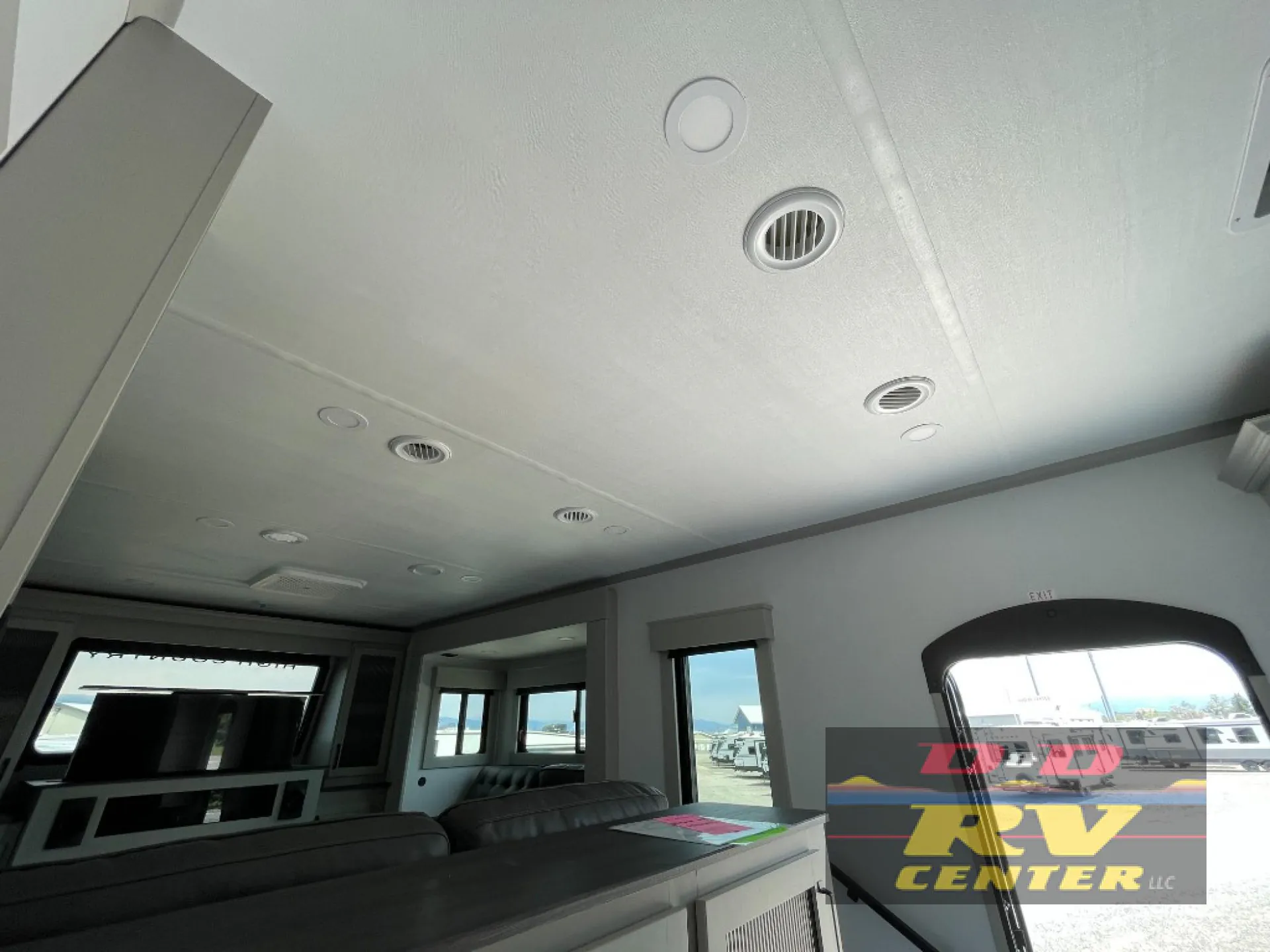 2026 Keystone Montana High Country 377FL — Living area with sofa seating, entertainment television, windows, and ceiling ventilation