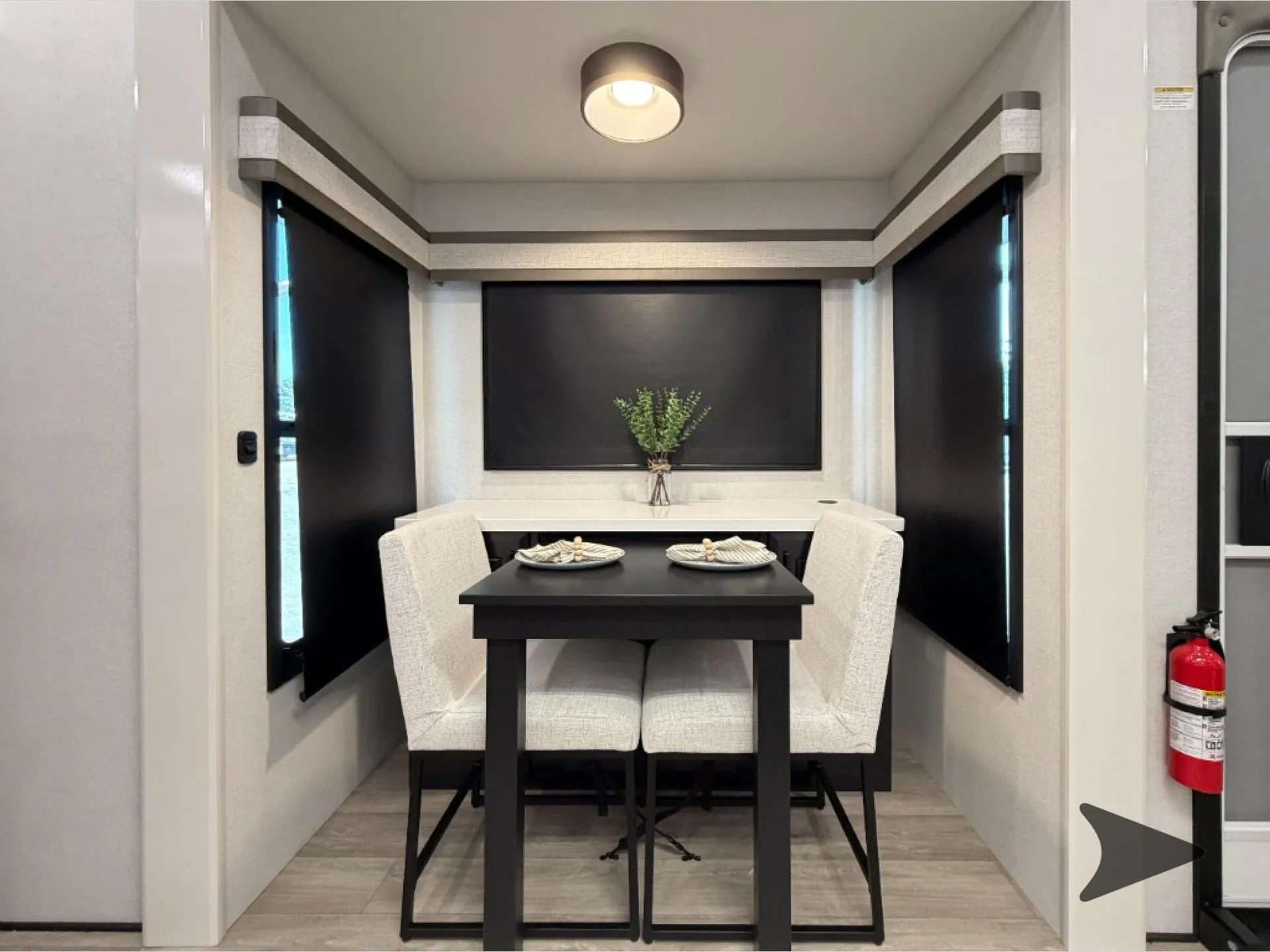 2027 Jayco Pinnacle 39FLOK — Freestanding dining table and four upholstered chairs positioned before a wall-mounted television and surrounding window shades