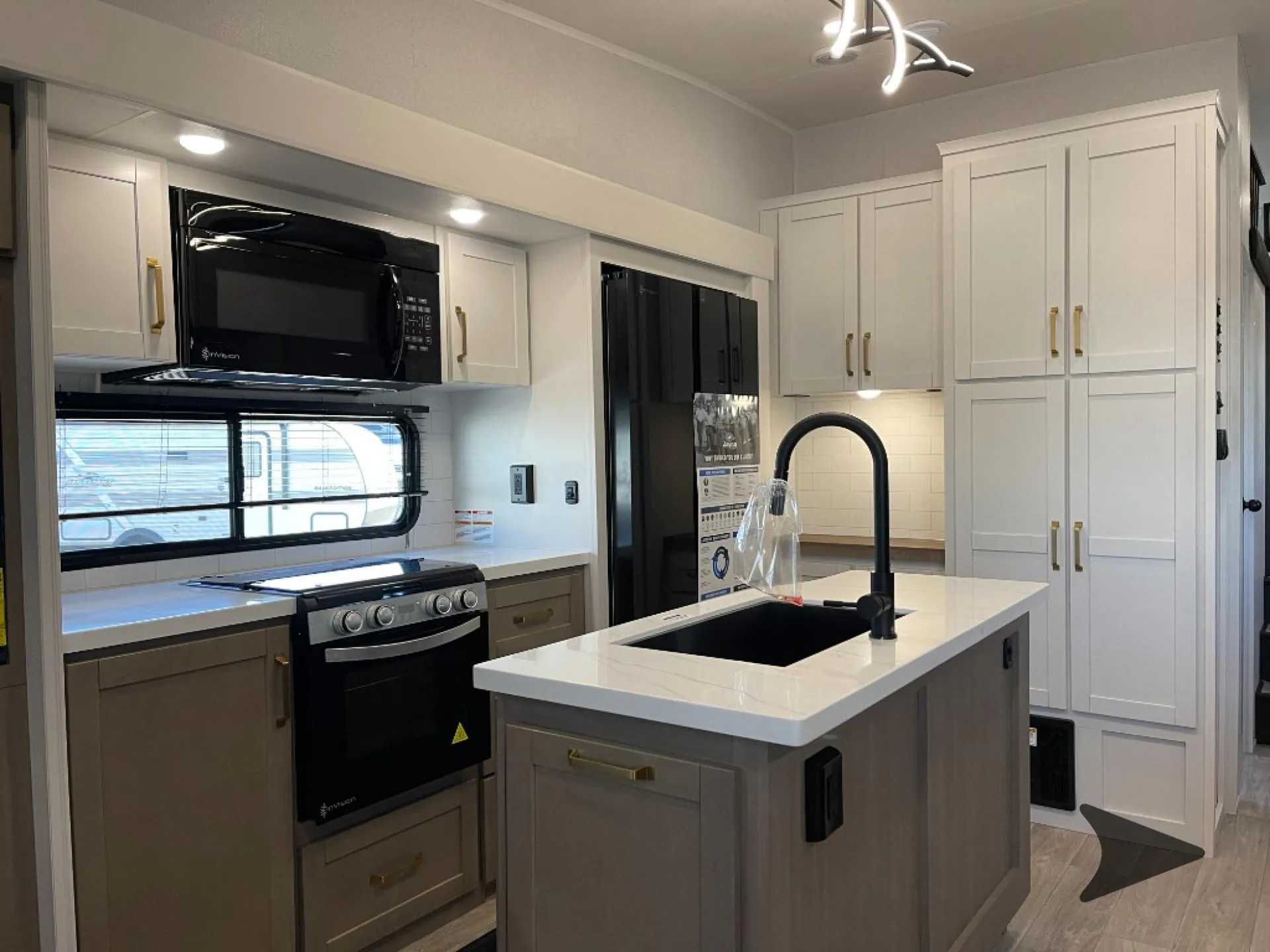 2027 Jayco Eagle 355MBQS — Fifth wheel kitchen close view of island sink, range, microwave, refrigerator, counters, and tall cabinetry