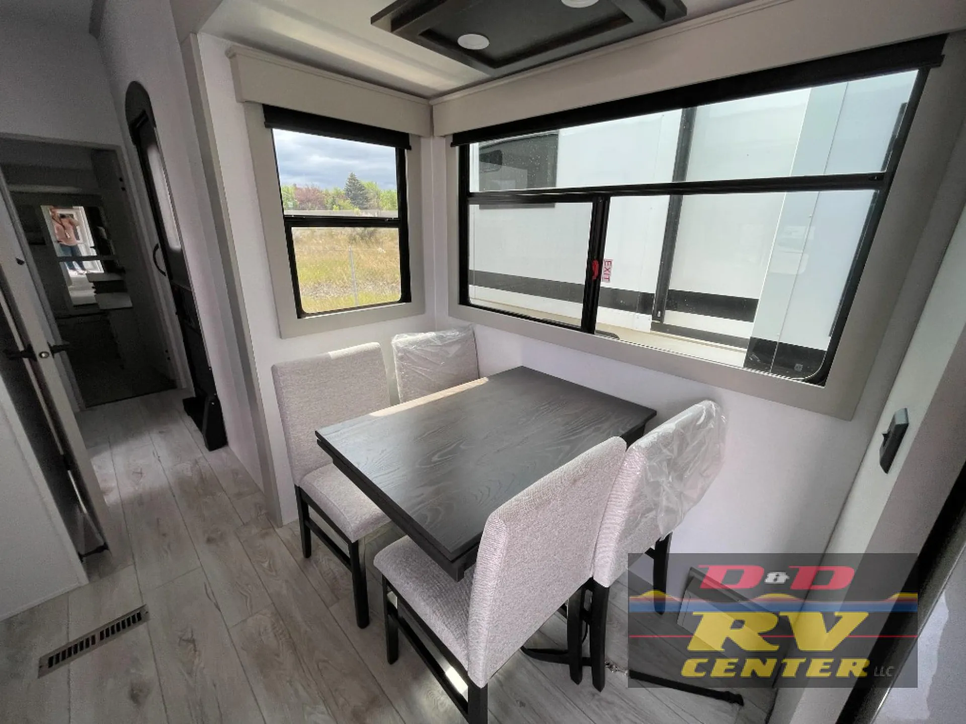 2026 Keystone Montana High Country 377FL — Freestanding dining table with four upholstered chairs beneath large windows