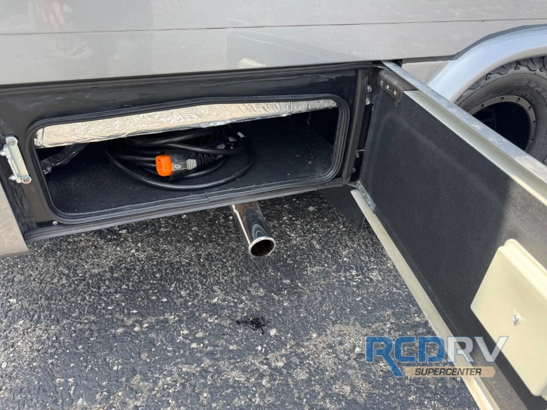 2025 Chinook RV Maverick SS — Open exterior compartment visibly contains a coiled cable and is mounted beneath the RV body