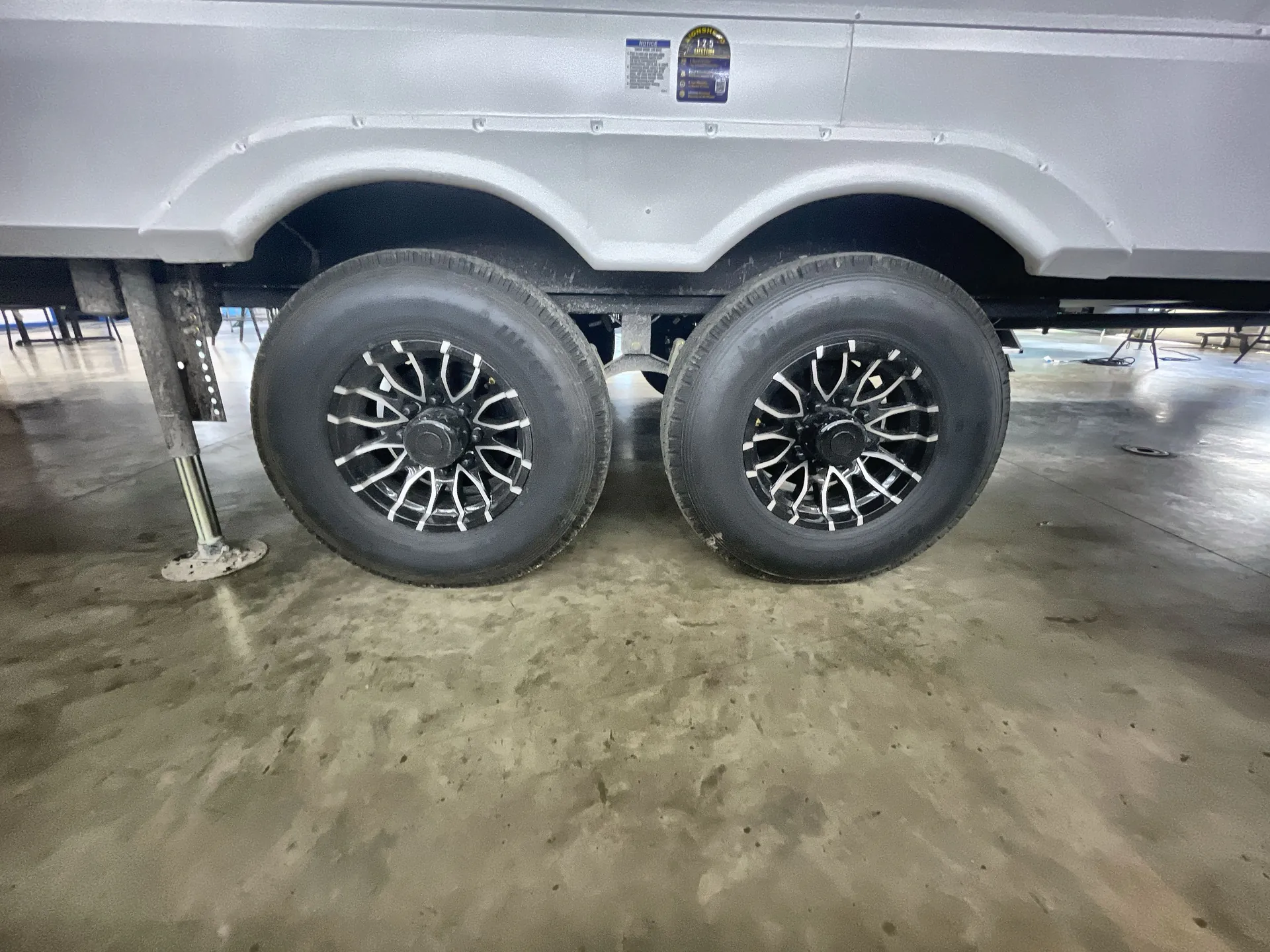2026 Forest River Arctic Wolf 38LEAH.G — Close exterior photograph of the RV's dual wheels, wheel wells, and underbody