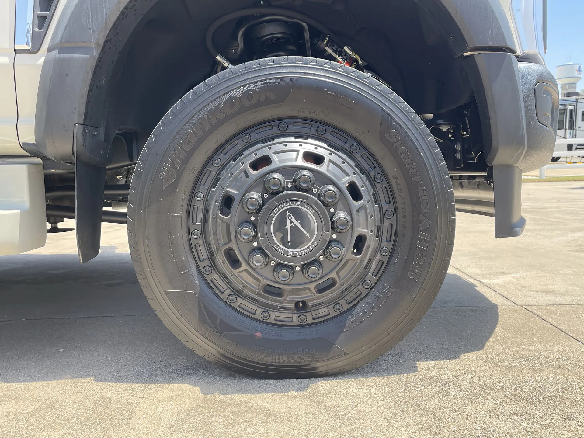 2027 Grand Design Lineage Series F 31ZW — Close exterior photograph of the RV wheel, tire, suspension area, and wheel well