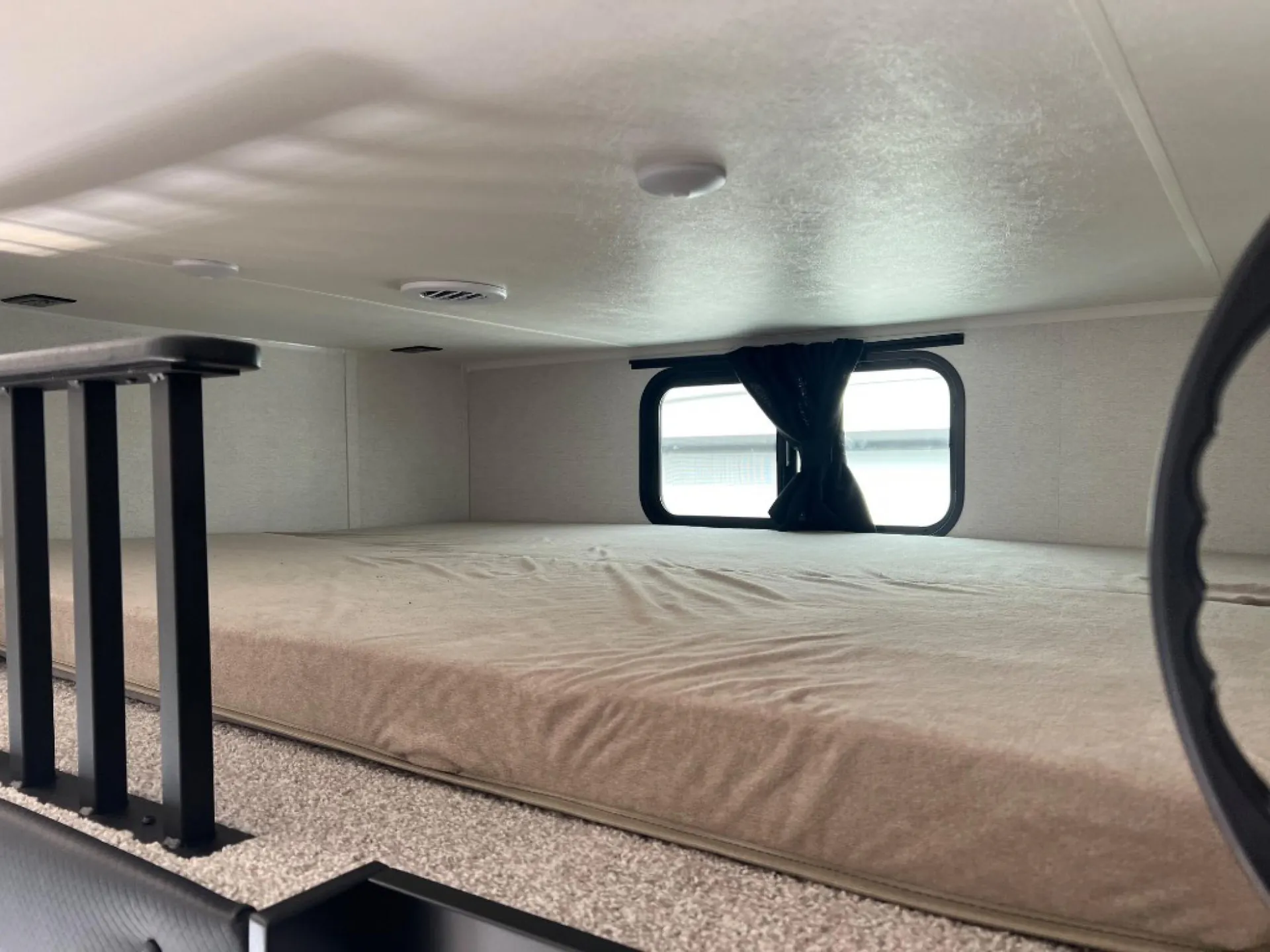 2027 Jayco Eagle 355MBQS — Elevated over-cab bunk with mattress, safety rail, ventilation, and curtained side window