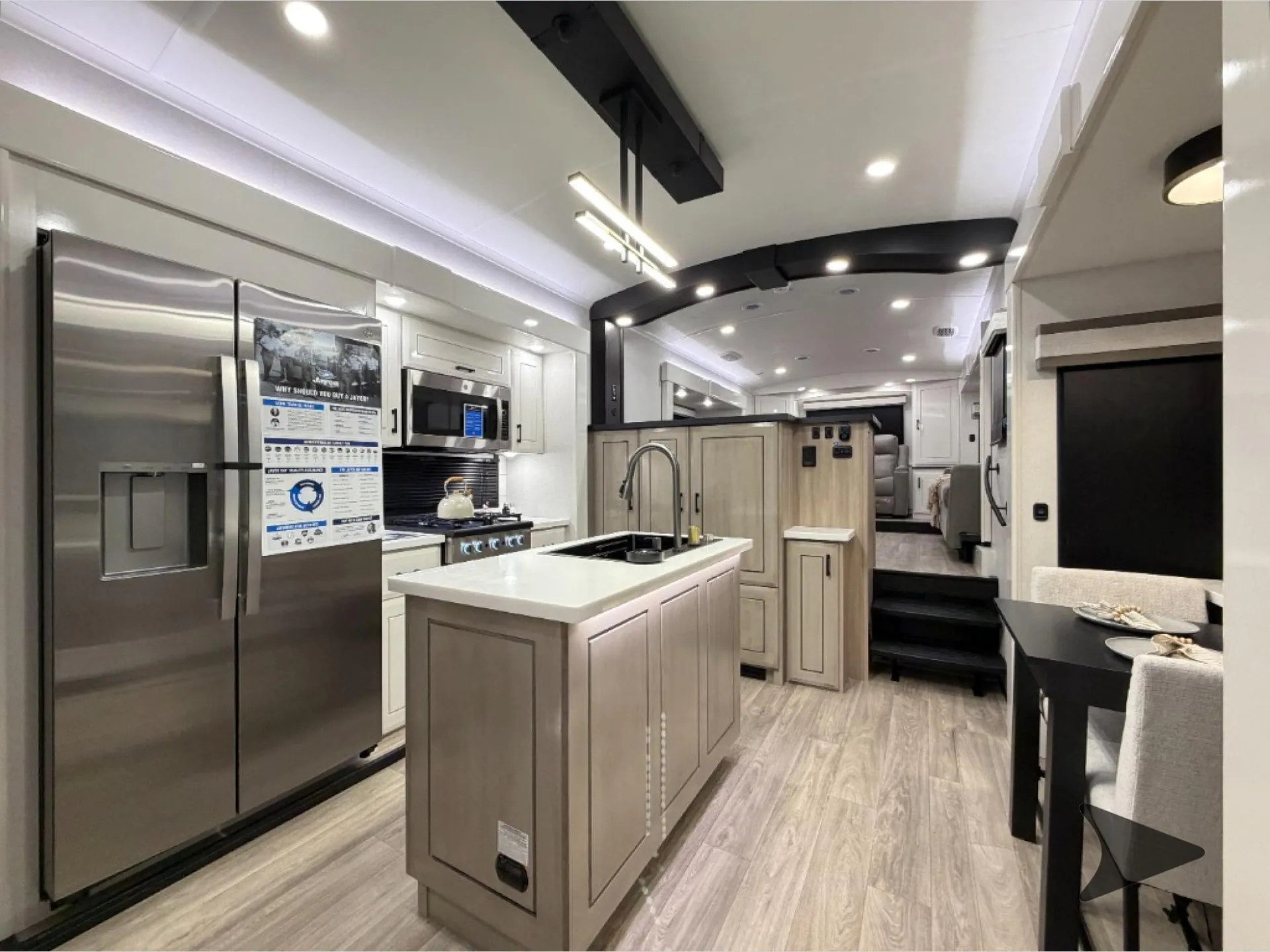 2027 Jayco Pinnacle 39FLOK — Fifth wheel kitchen with island sink, refrigerator, range, microwave, adjacent dining table, and living seating beyond