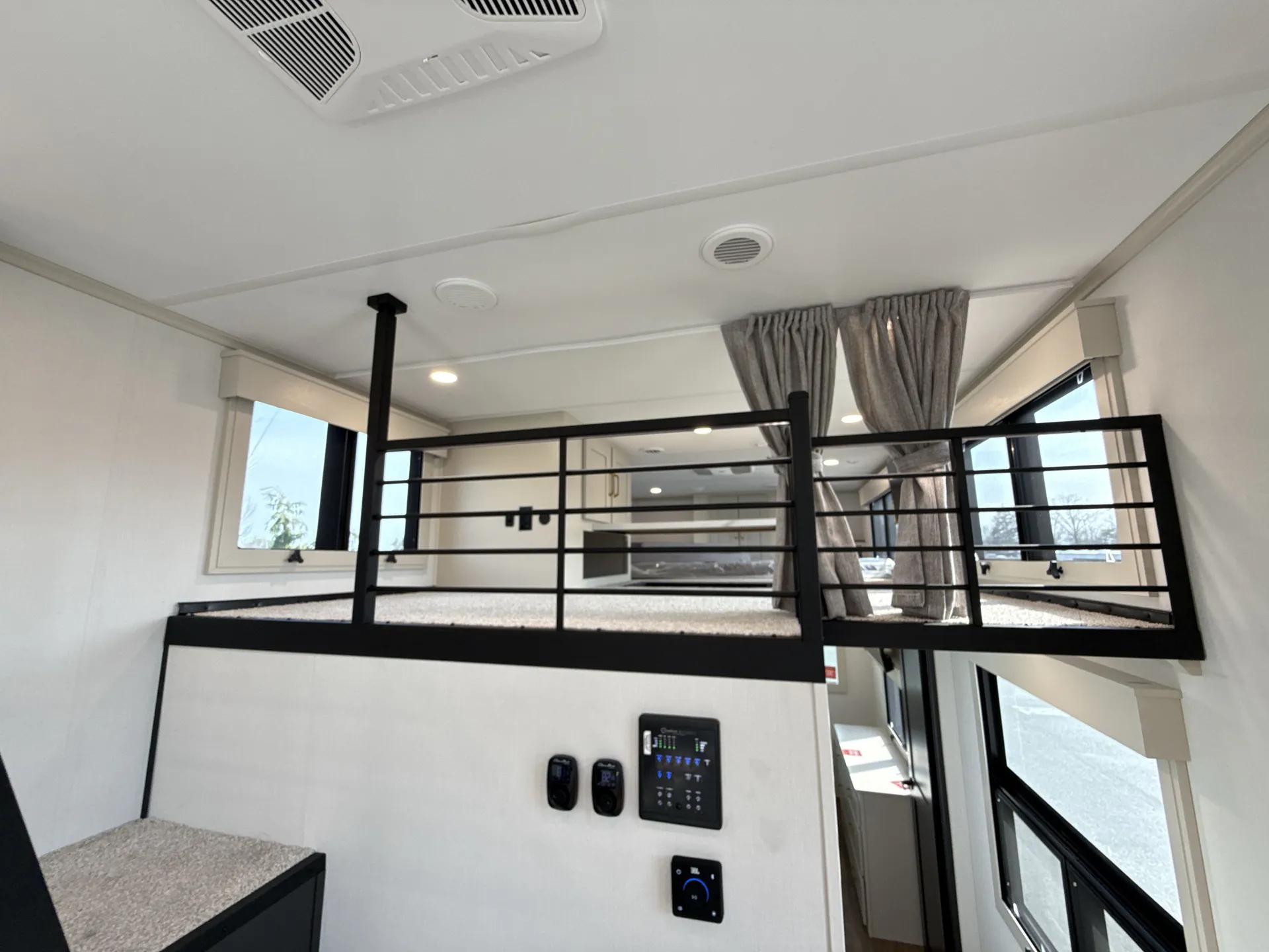 2026 Grand Design Foundation 42GD — Elevated sleeping loft with safety rails above a lower bedroom area and visible control panel