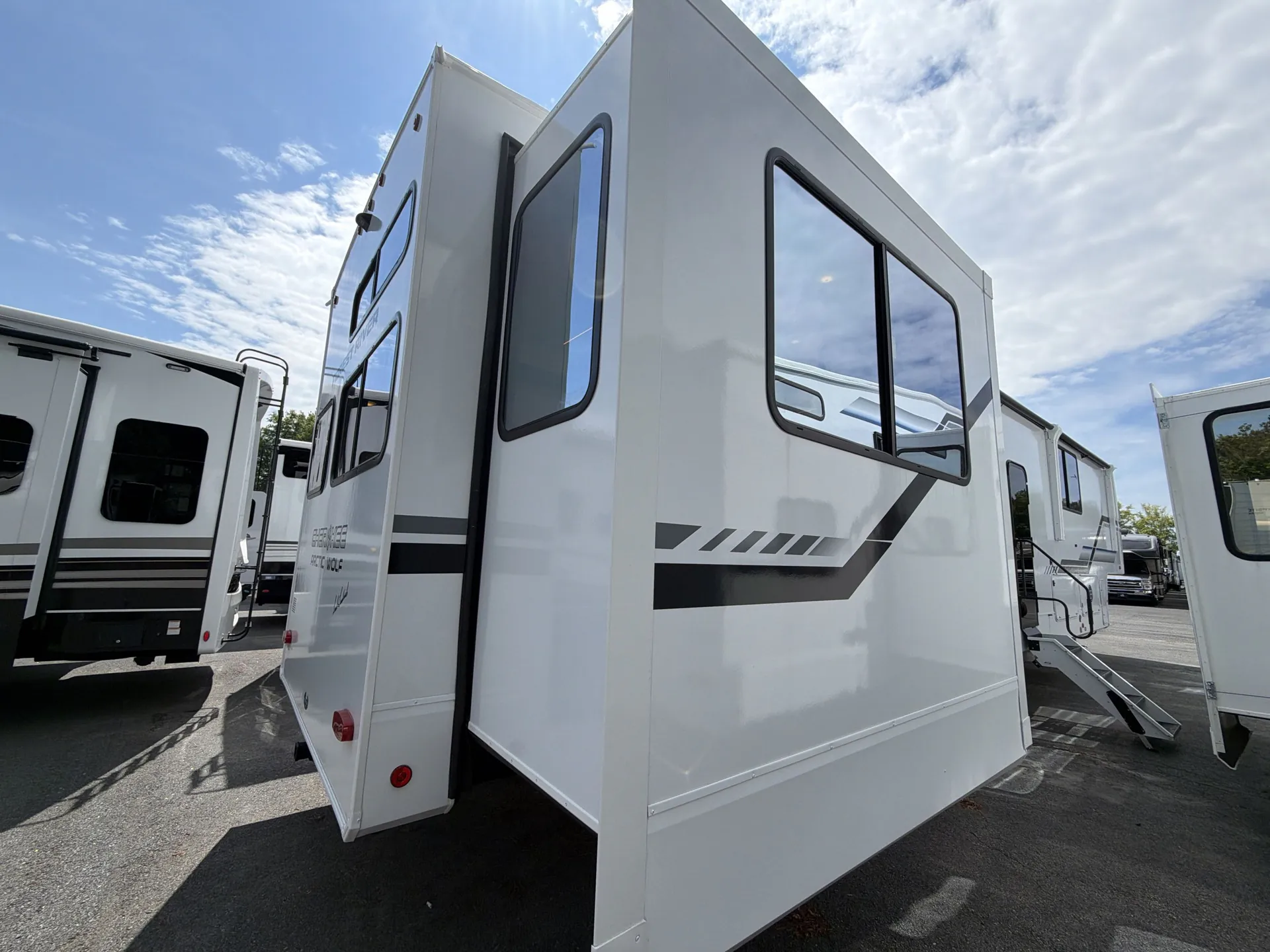 2026 Forest River Arctic Wolf 38LEAH.G — The outside side and rear corner of a fifth-wheel RV, including exterior walls, windows, slide-out, and graphics