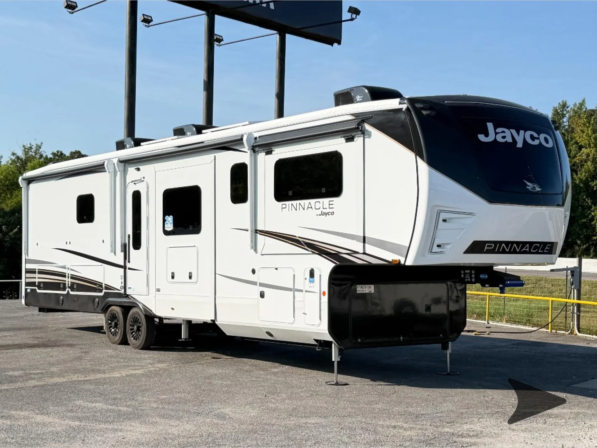 2027 Jayco Pinnacle 39FLOK — The outside front and side of a Jayco Pinnacle fifth-wheel RV, including shell, hitch, wheels, and awnings