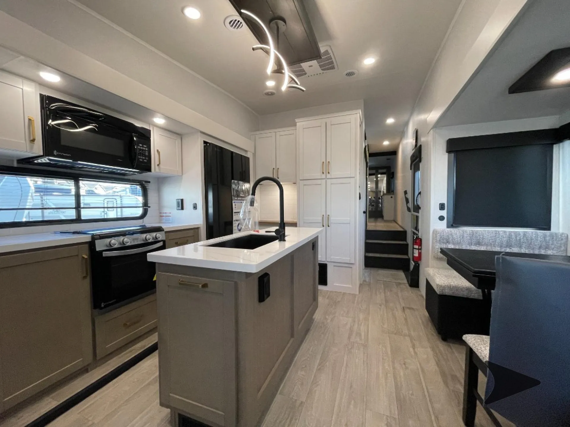2027 Jayco Eagle 355MBQS — Fifth wheel kitchen with island sink, range, microwave, refrigerator, pantry cabinets, and adjacent dinette