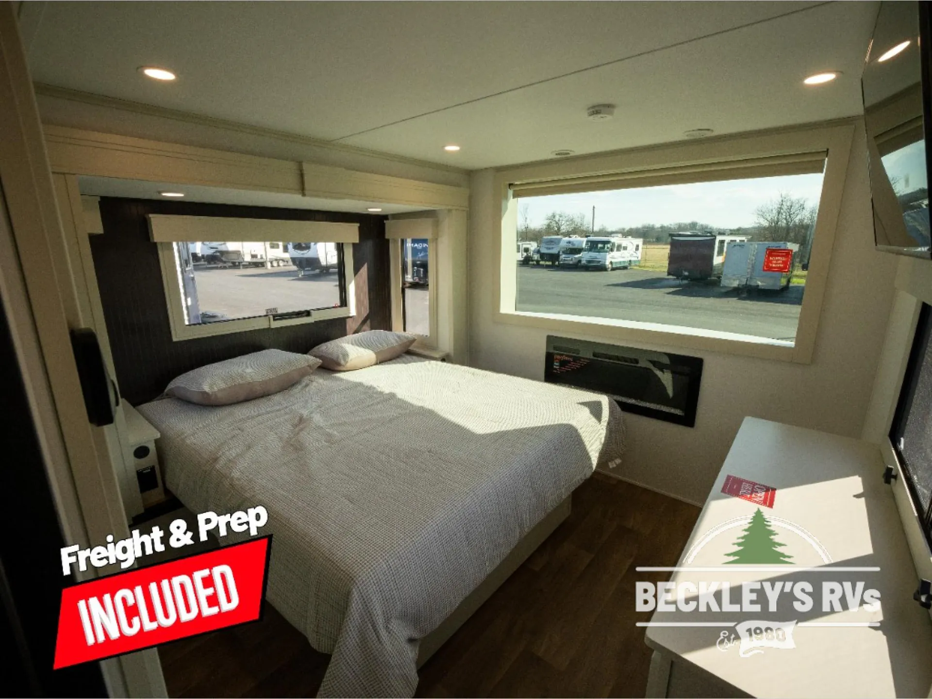 2026 Grand Design Foundation 42GD — Destination trailer bedroom with a made bed, large windows, wall-mounted television, and dresser