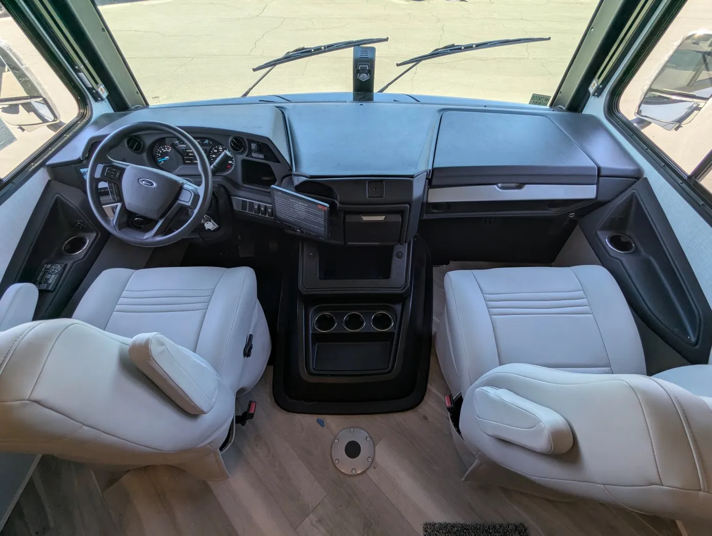 2026 Holiday Rambler Invicta 36Y — Class A cockpit with steering wheel, instrument cluster, dashboard controls, and two captain’s chairs