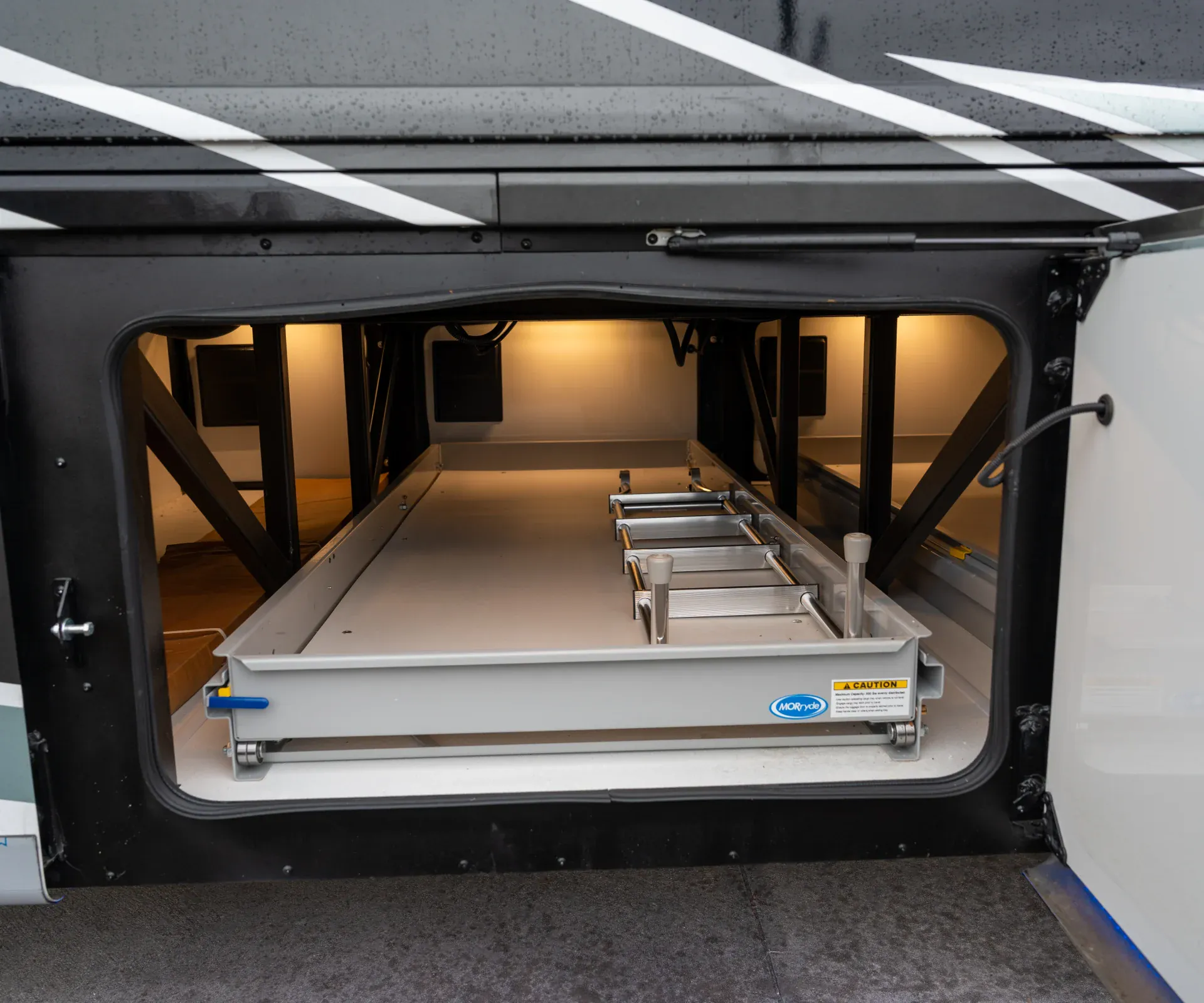 2026 Fleetwood Discovery LXE 40G — Open exterior cargo bay visibly shows a slide-out tray and stored equipment