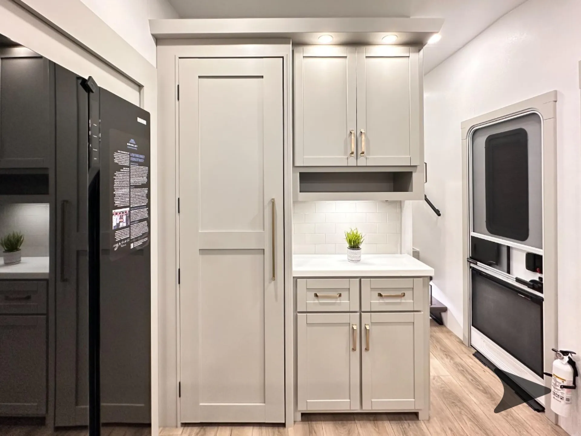 2026 Brinkley Model Z 3610 — Fifth wheel kitchen with a refrigerator, pantry door, upper and lower cabinets, countertop, backsplash, and entry door
