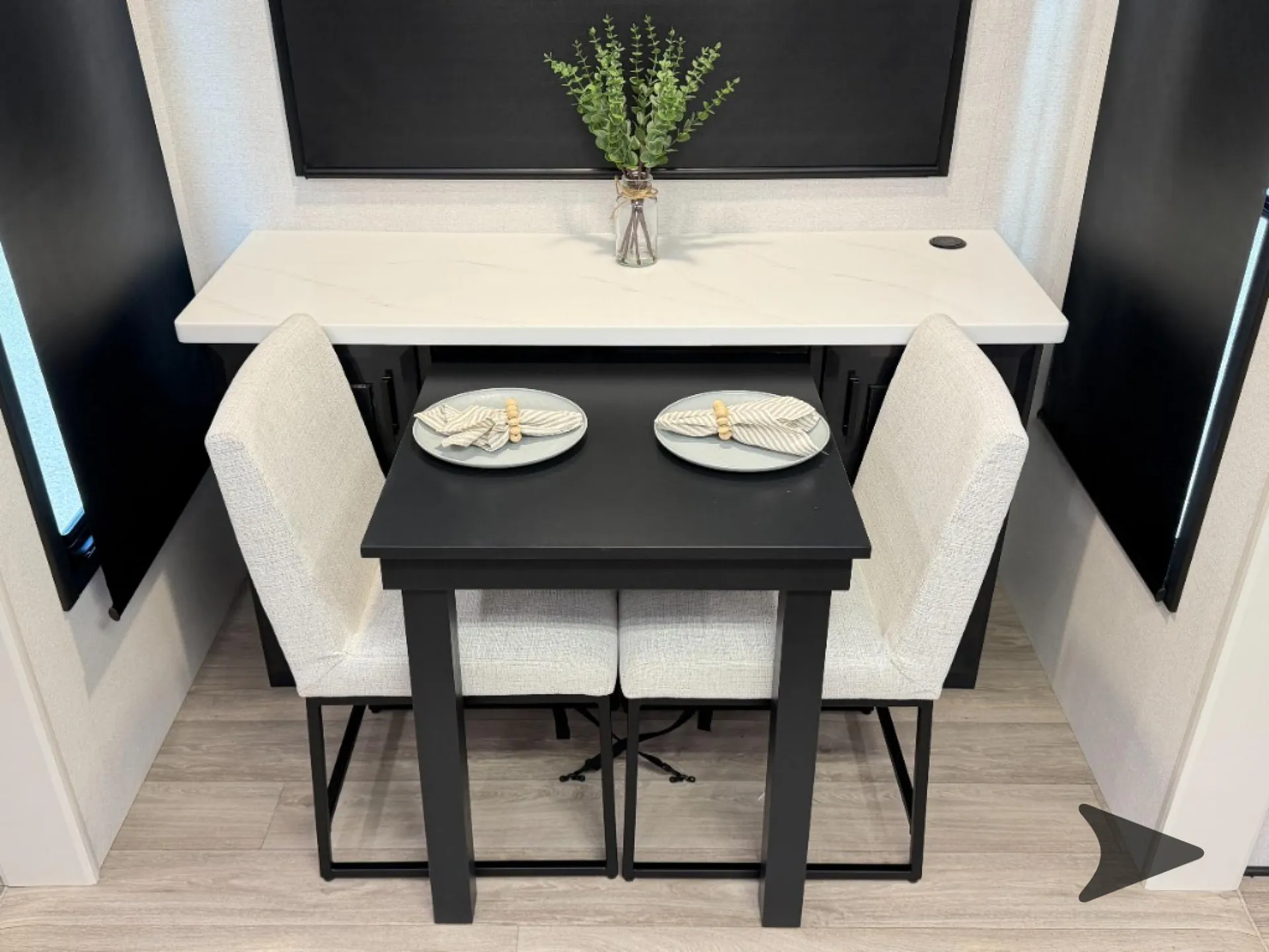 2027 Jayco Pinnacle 39FLOK — Freestanding dining table set with two upholstered chairs, place settings, and a wall-mounted television behind it