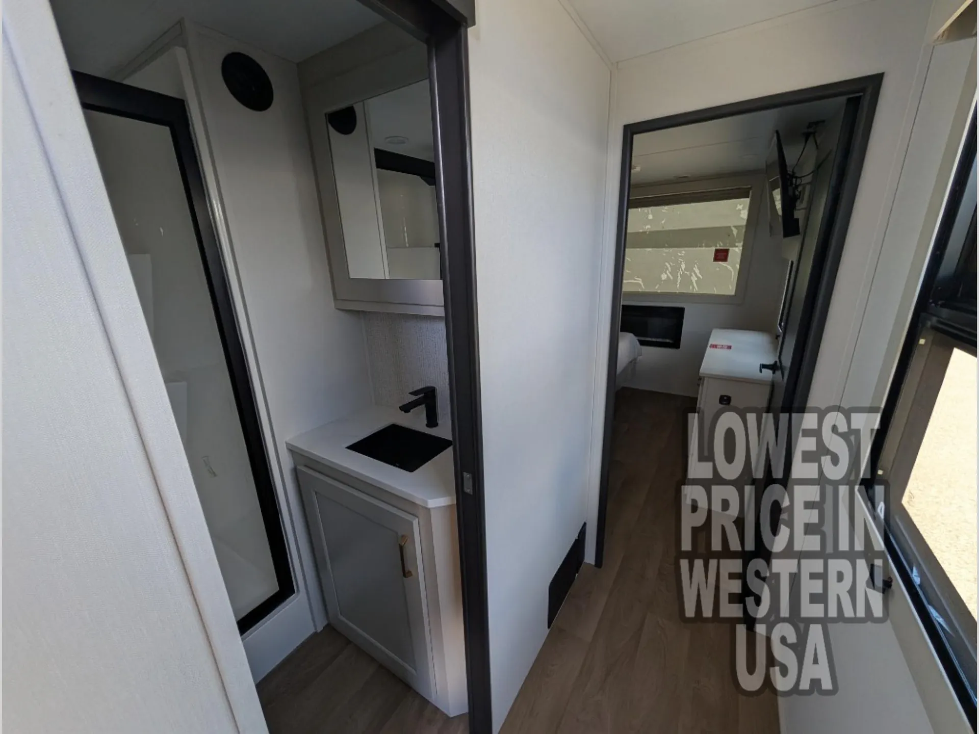 2026 Grand Design Foundation 42GD — Hallway view centered on a bathroom vanity with sink, mirror, and adjacent shower doorway