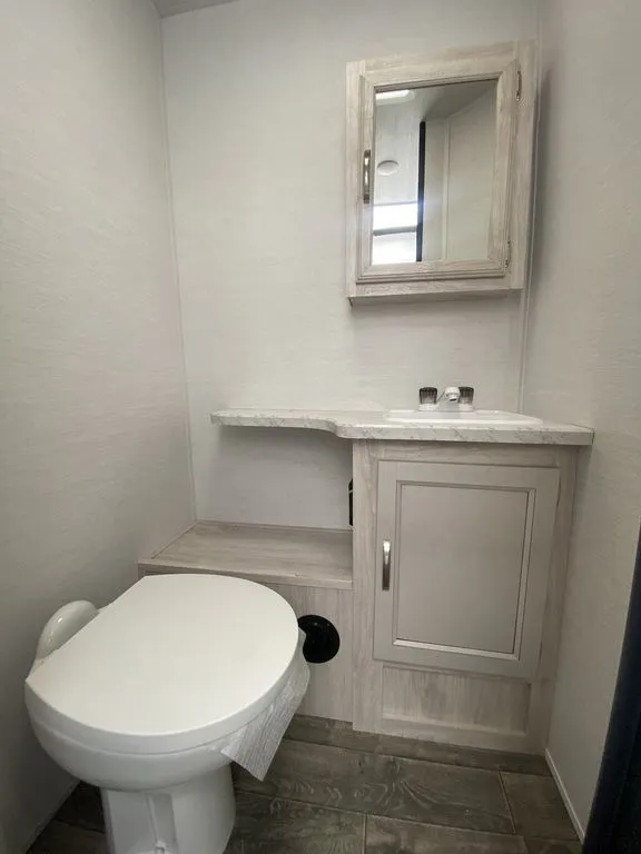 2026 Gulf Stream Vista Cruiser 19ERD — Travel trailer bathroom with toilet, vanity cabinet, sink counter, mirror, and shelving