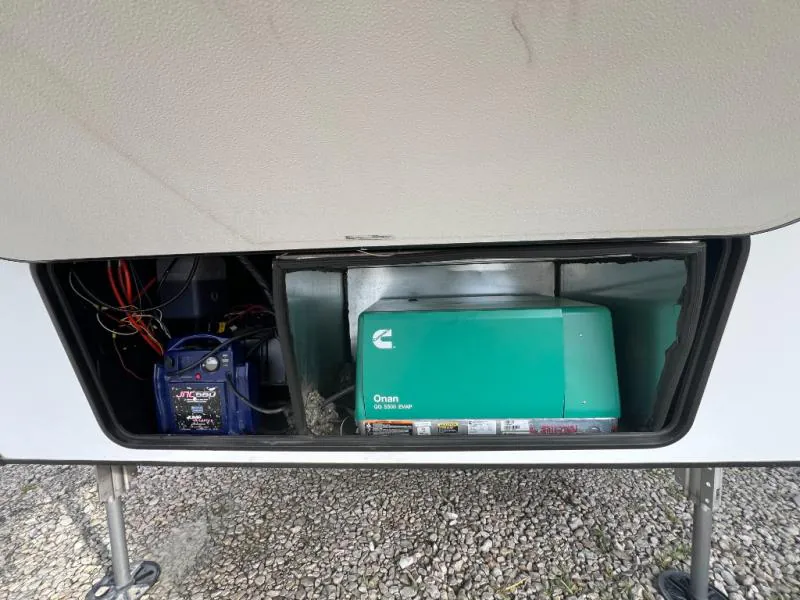 2023 Dutchmen Voltage 4225 — Exterior service compartment visibly contains a generator and battery/electrical equipment