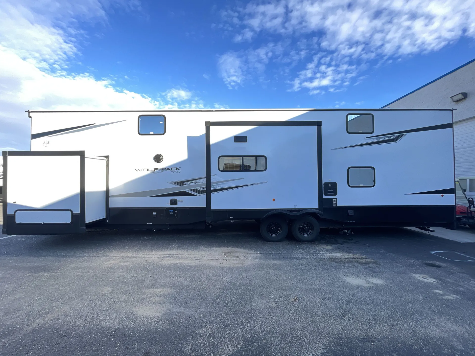 2026 Forest River Cherokee Wolf Pack 397STAY — Side exterior photograph visibly shows the full trailer body, slide-outs, wheels, and exterior-installed features