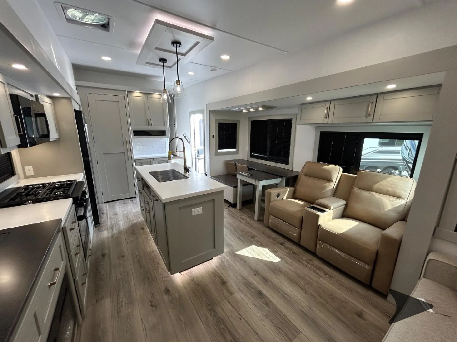 2026 Brinkley Model Z 3515 — Fifth wheel interior showing kitchen island beside recliners, sofa, and dining table