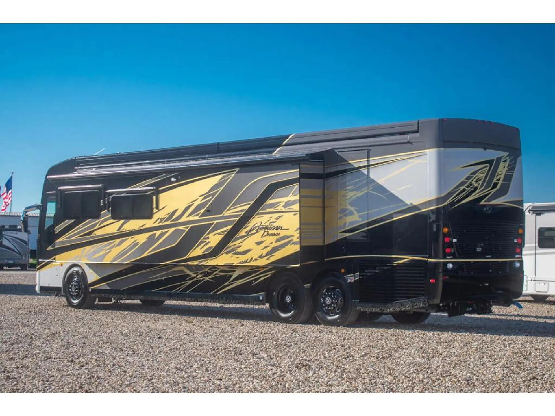2026 American Coach American Dream 45A — Rear three-quarter photograph visibly shows the motorhome's exterior body, windows, wheels, and rear section