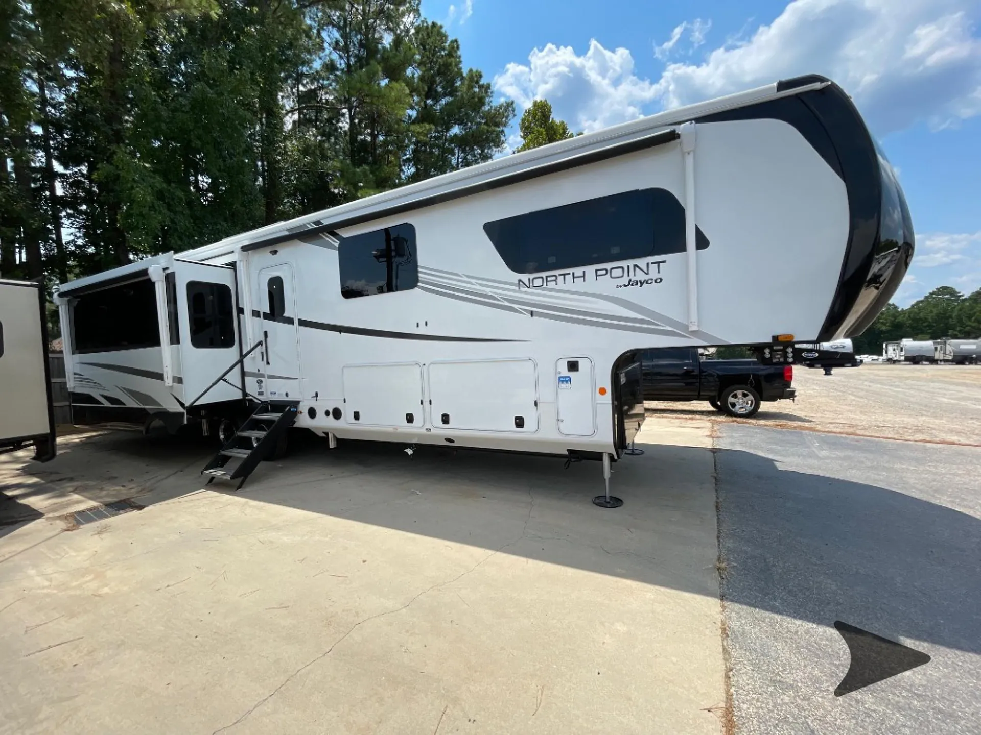 2026 Jayco North Point 377RLBH — The RV's exterior side, awning, entrance steps, and storage doors