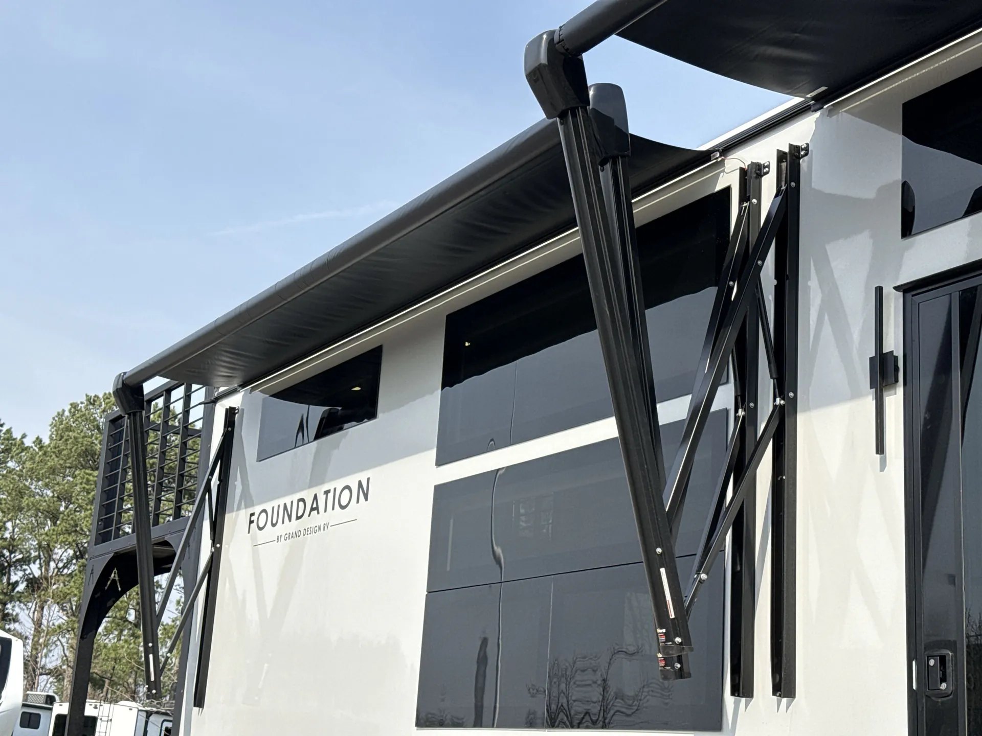2026 Grand Design Foundation 42GD — Wide photograph visibly shows the RV exterior, awning, patio railing, windows, and entry door