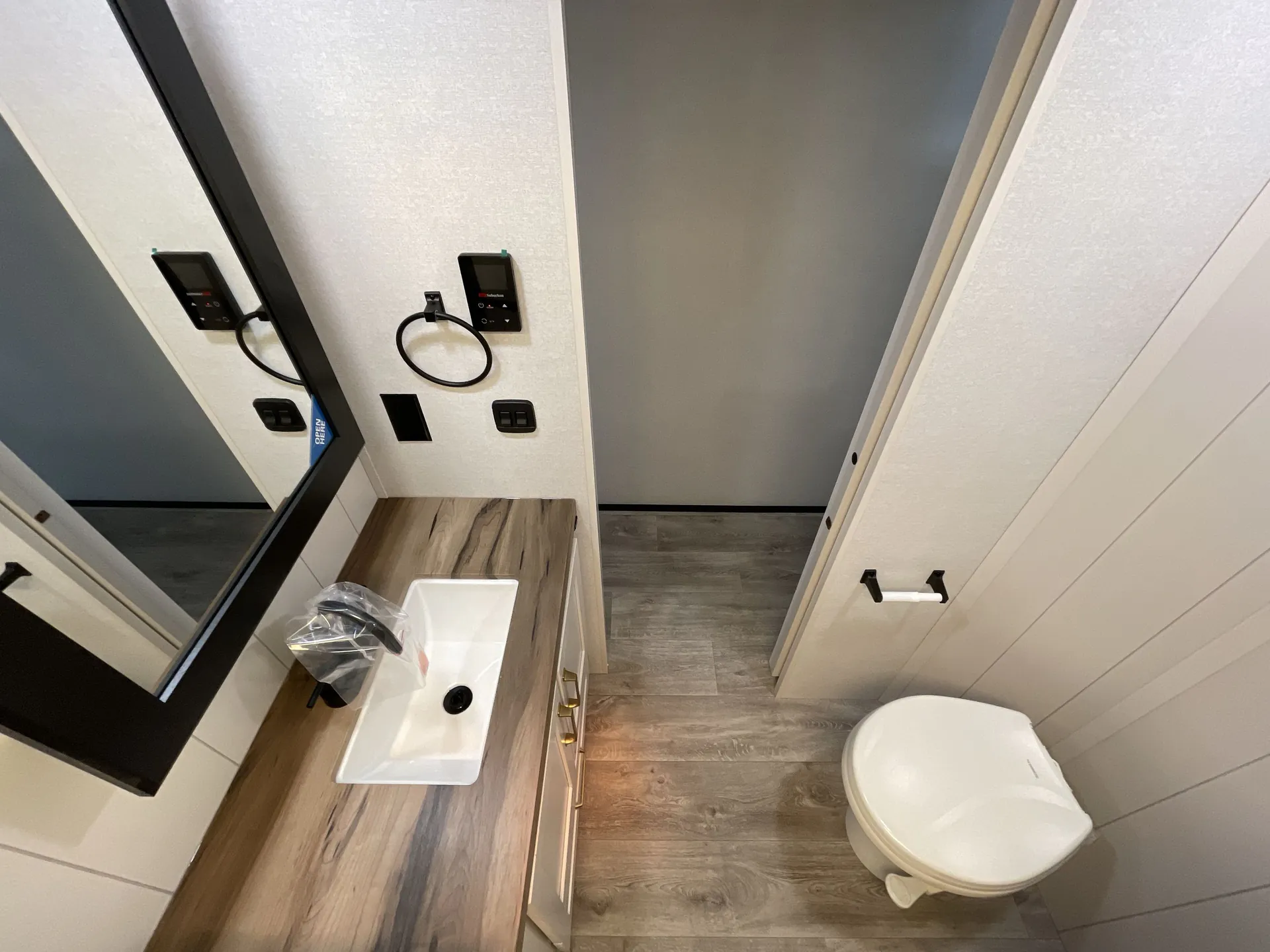 2027 Jayco Eagle 355MBQS — Fifth wheel bathroom with vanity sink, wood-look countertop, toilet, mirror, and floor controls