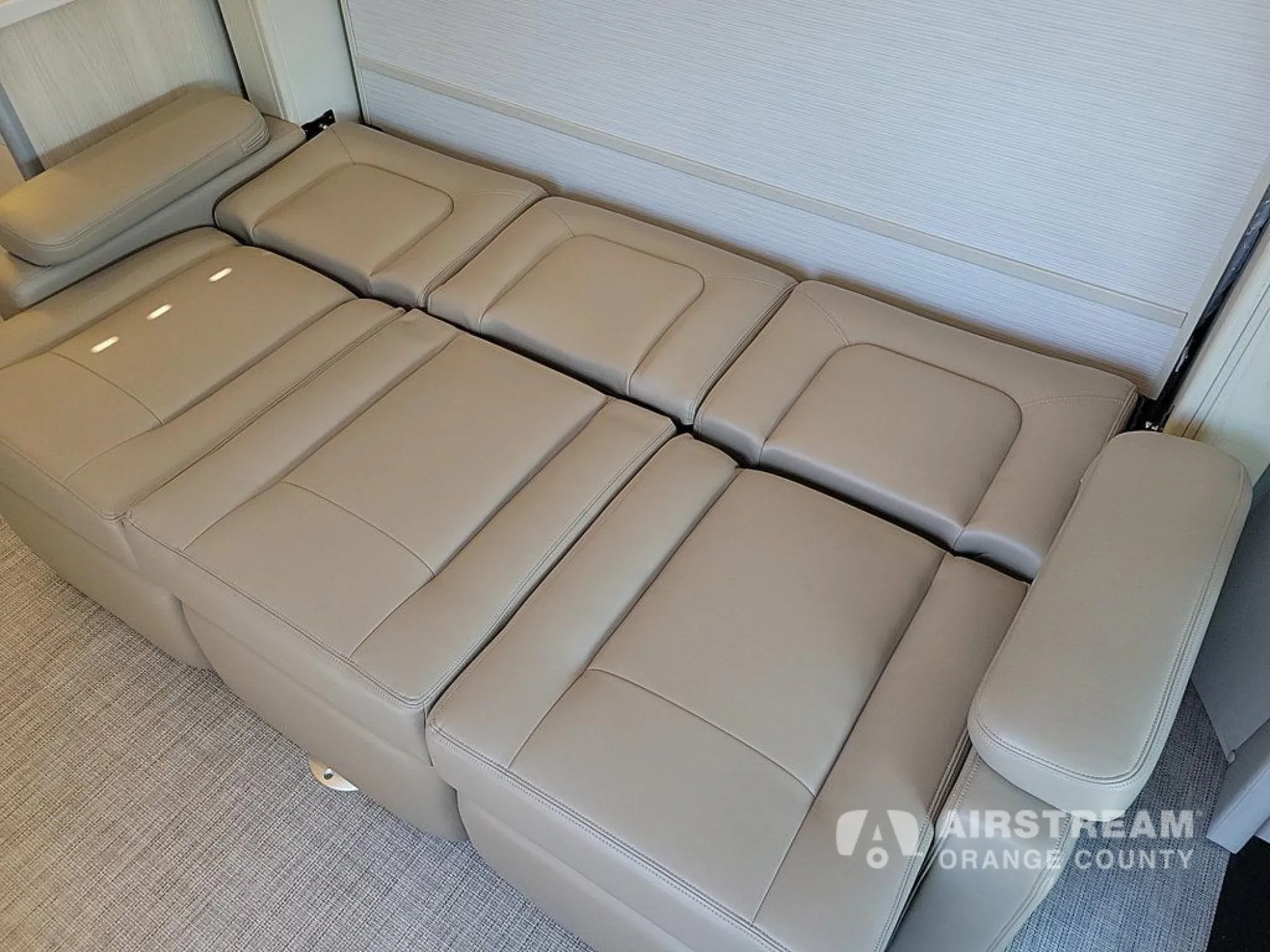 2026 Airstream Atlas Murphy Suite — Reclining lounge seats are arranged into a continuous flat seating surface on the carpeted floor