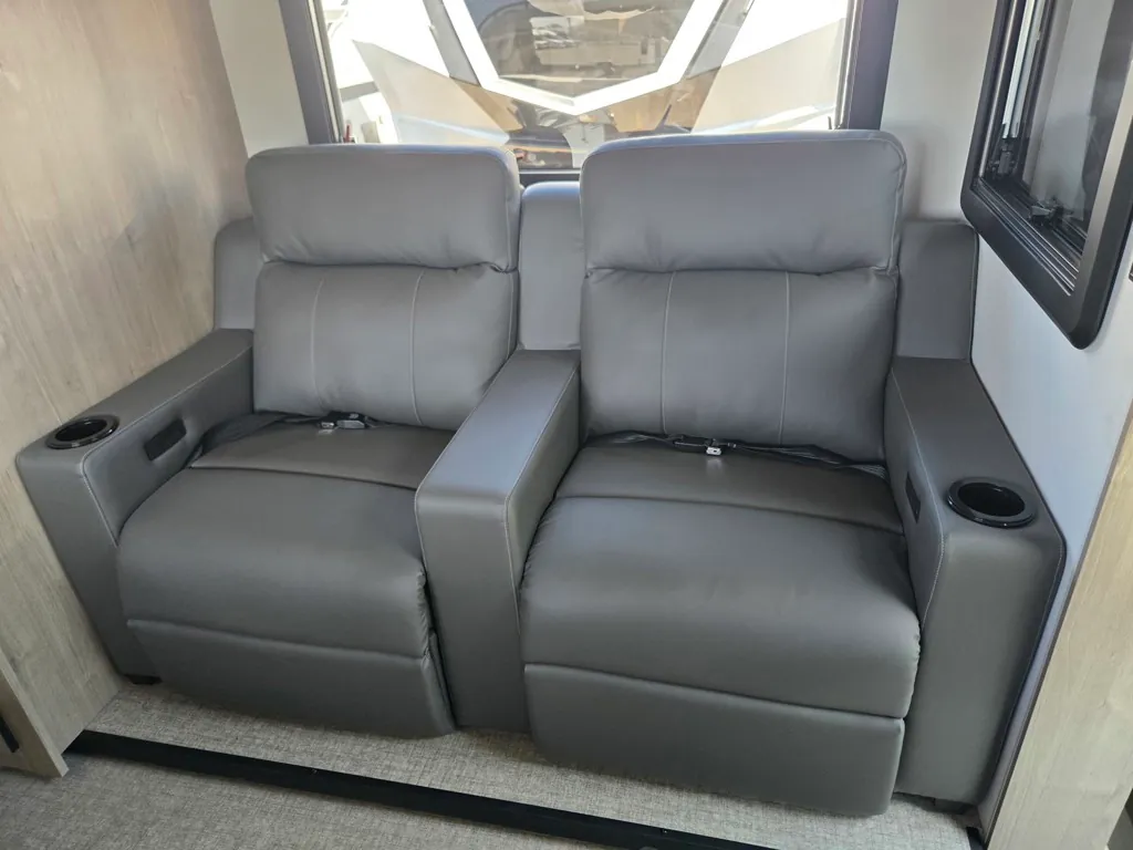 2027 Grand Design Lineage Series F 29AN5 — Pair of gray powered recliners with shared armrest, cupholders, and large front cab windshield