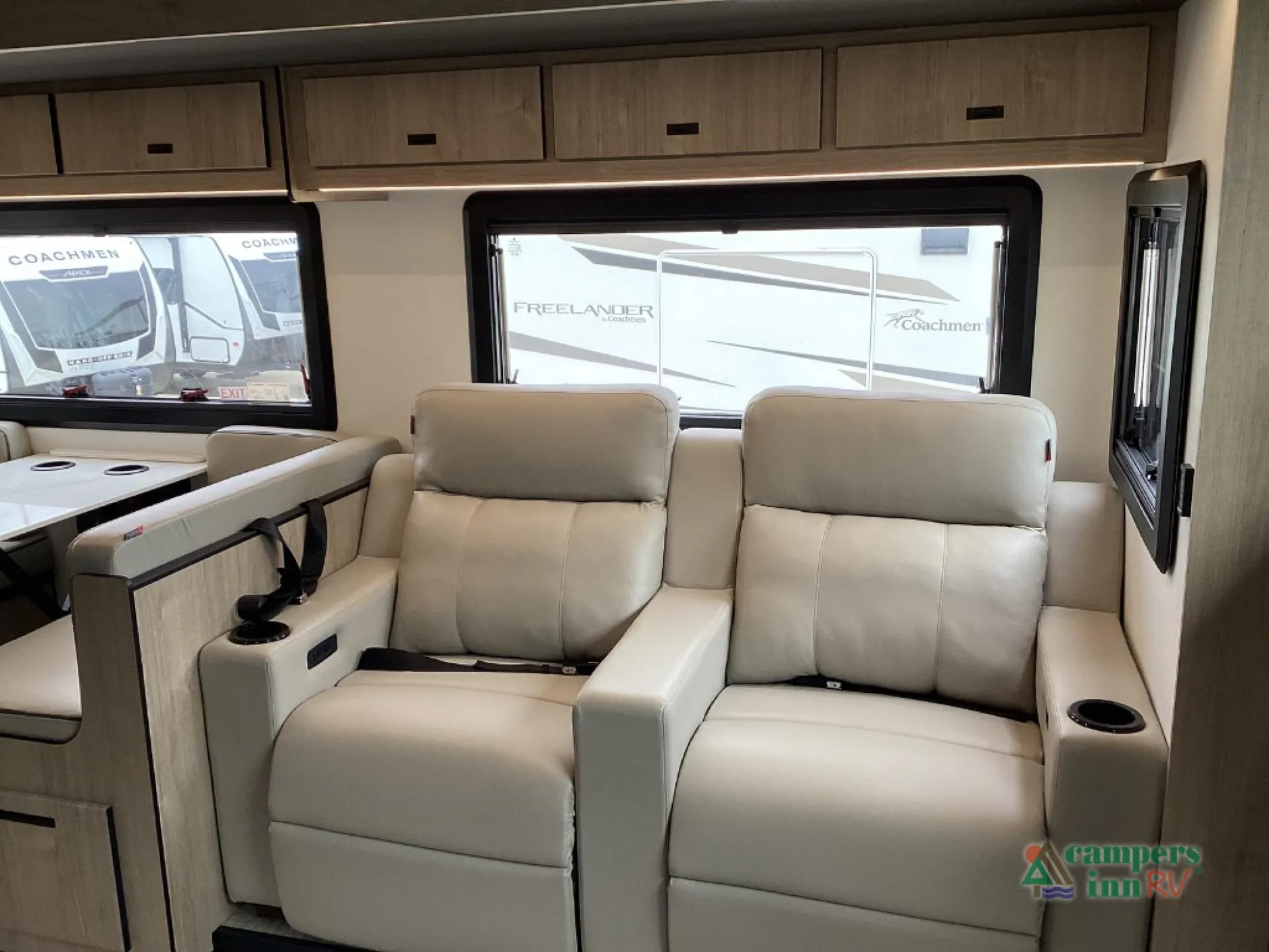 2027 Grand Design Lineage Series F 31ZW — Two reclining lounge seats with cupholders, overhead cabinets, and surrounding windows inside the motorhome