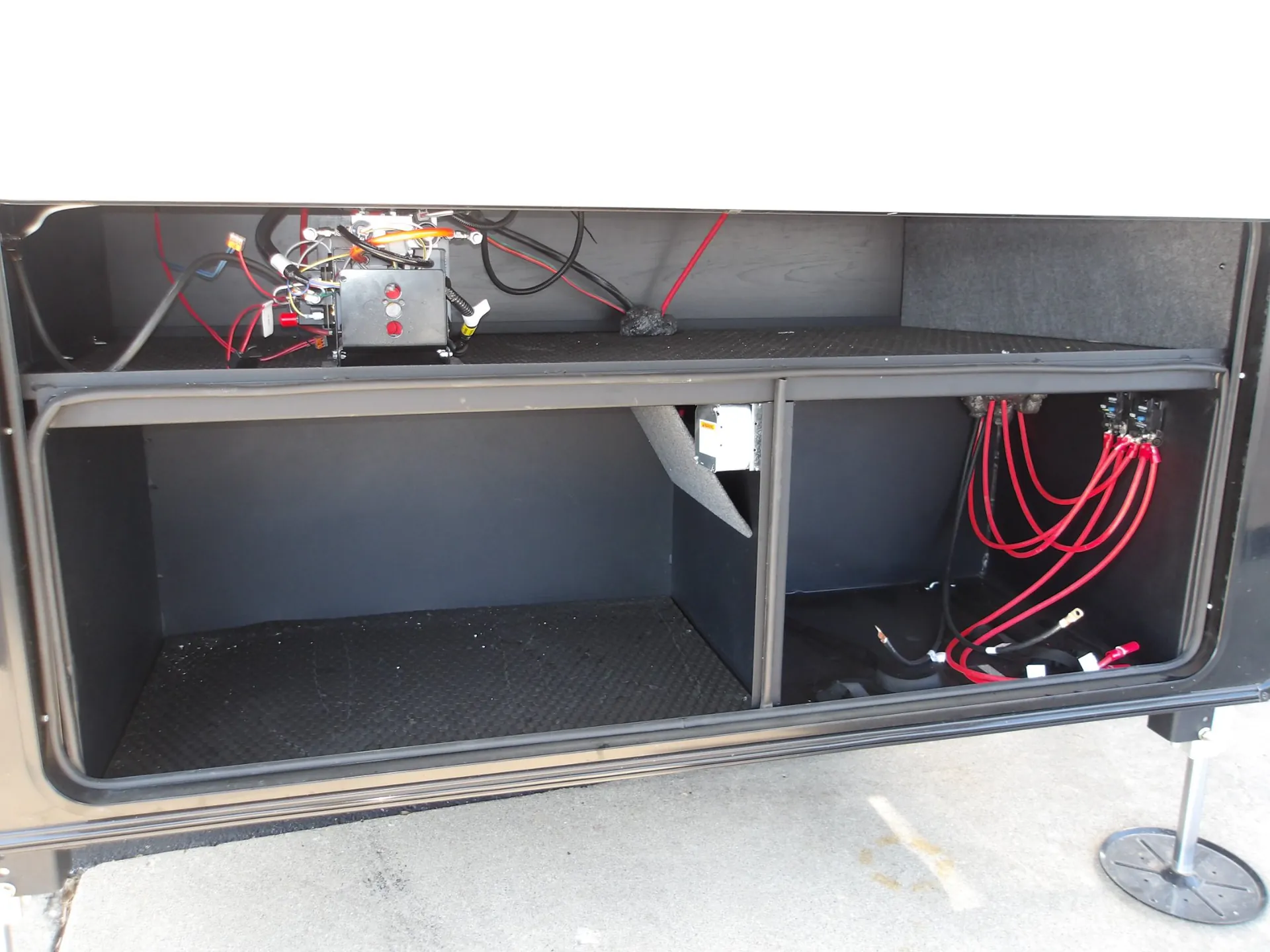 2027 Jayco Pinnacle 39FLOK — Open exterior compartment visibly contains wiring, electrical components, and service equipment